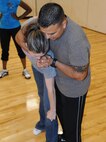 LAUGHLIN AIR FORCE BASE, Texas – Tech. Sgt. Diana Vela and Staff Sgt. Bryan Garcia, both of the 47th Security Forces Squadron, demonstrate self defense techniques to a class at Laughlin’s Losano Fitness Center April 21. The class is in recognition of sexual assault awareness month and takes place at the end of the Zumba classes at the gym. (U.S. Air Force photo by Airman 1st Class Blake Mize)