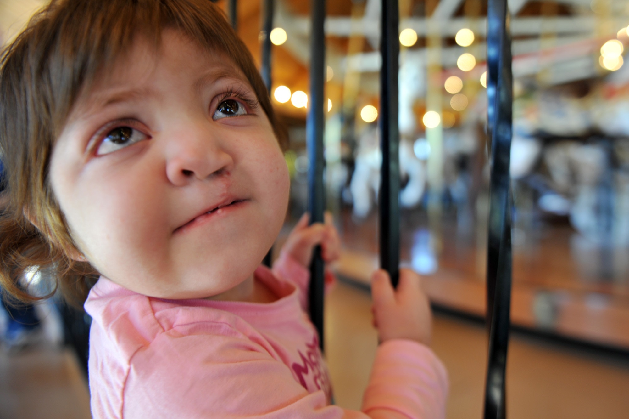 Braelyn Whitford looks up at her dad before getting ready to ride the Looff Carrousel in Spokane, Wash., on Apr. 9, 2011. Braelyn is diagnosed with Kabuki Syndrome. Braelyn and her family are assisted through the Exceptional Family Member Program which connects active duty family members who have special needs with many helping agencies both on- and off- base. (U.S. Air Force photo/Staff Sgt. Desiree N. Palacios)
