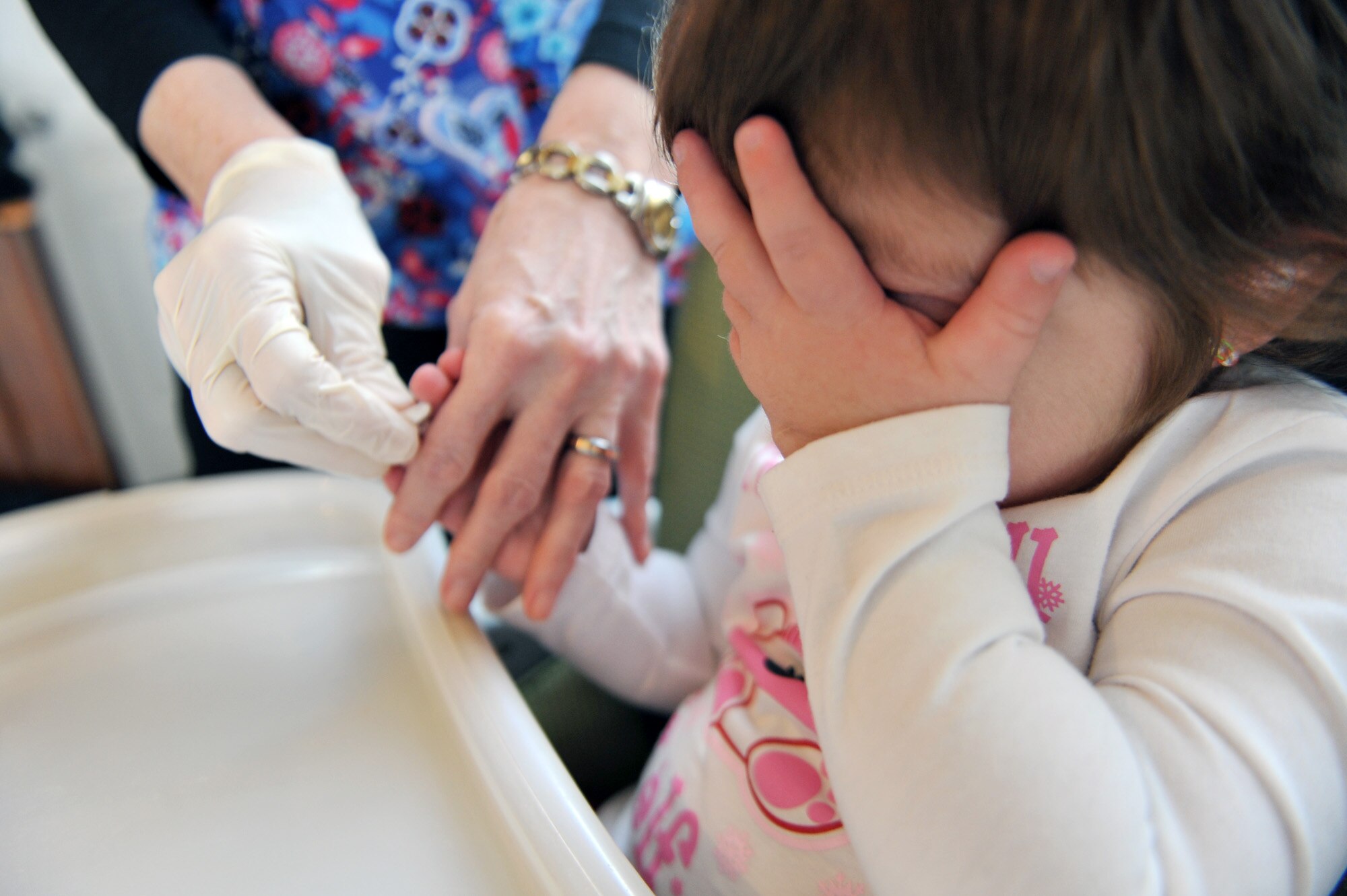 Braelyn Whitford covers her eyes as she prepare to get her finger pricked with a needle at her home in Spokane, Wash., on Apr. 5, 2011. Braelyn is diagnosed with Kabuki Syndrome. Braelyn and her family are assisted through the Exceptional Family Member Program which connects active duty family members who have special needs with many helping agencies both on- and off- base. (U.S. Air Force photo/Staff Sgt. Desiree N. Palacios)
