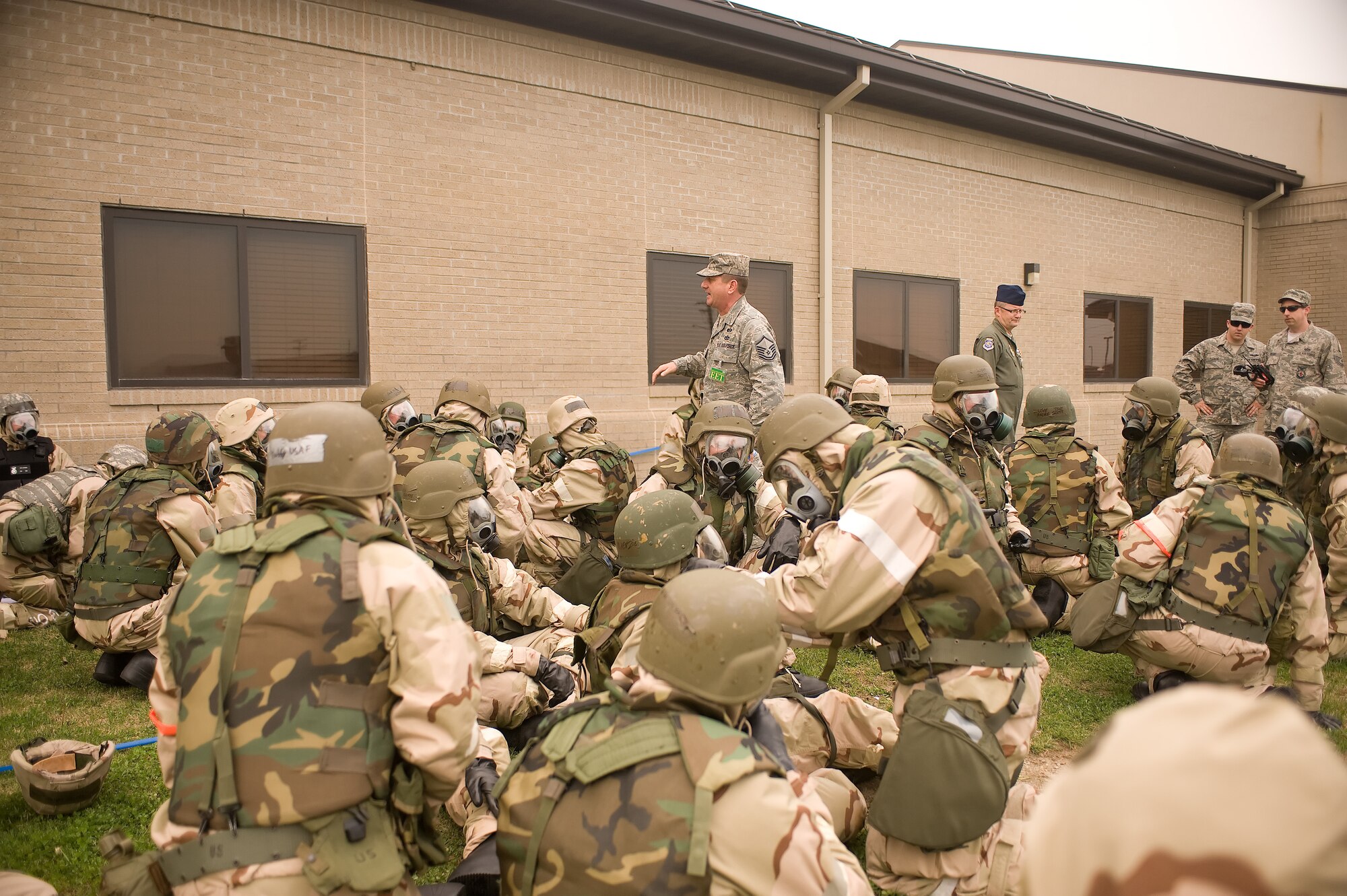 Team Dover members listen to a information brief from the Ability to Survive and Operate evaluator April 20, 2011, at Dover Air Force Base, Del. ATSO gave Team Dover Airmen a chance to practice their Personal Area Reconnaissance and Self Aid and Buddy Care skills. (U.S. Air Force photo by Steve Kotecki)