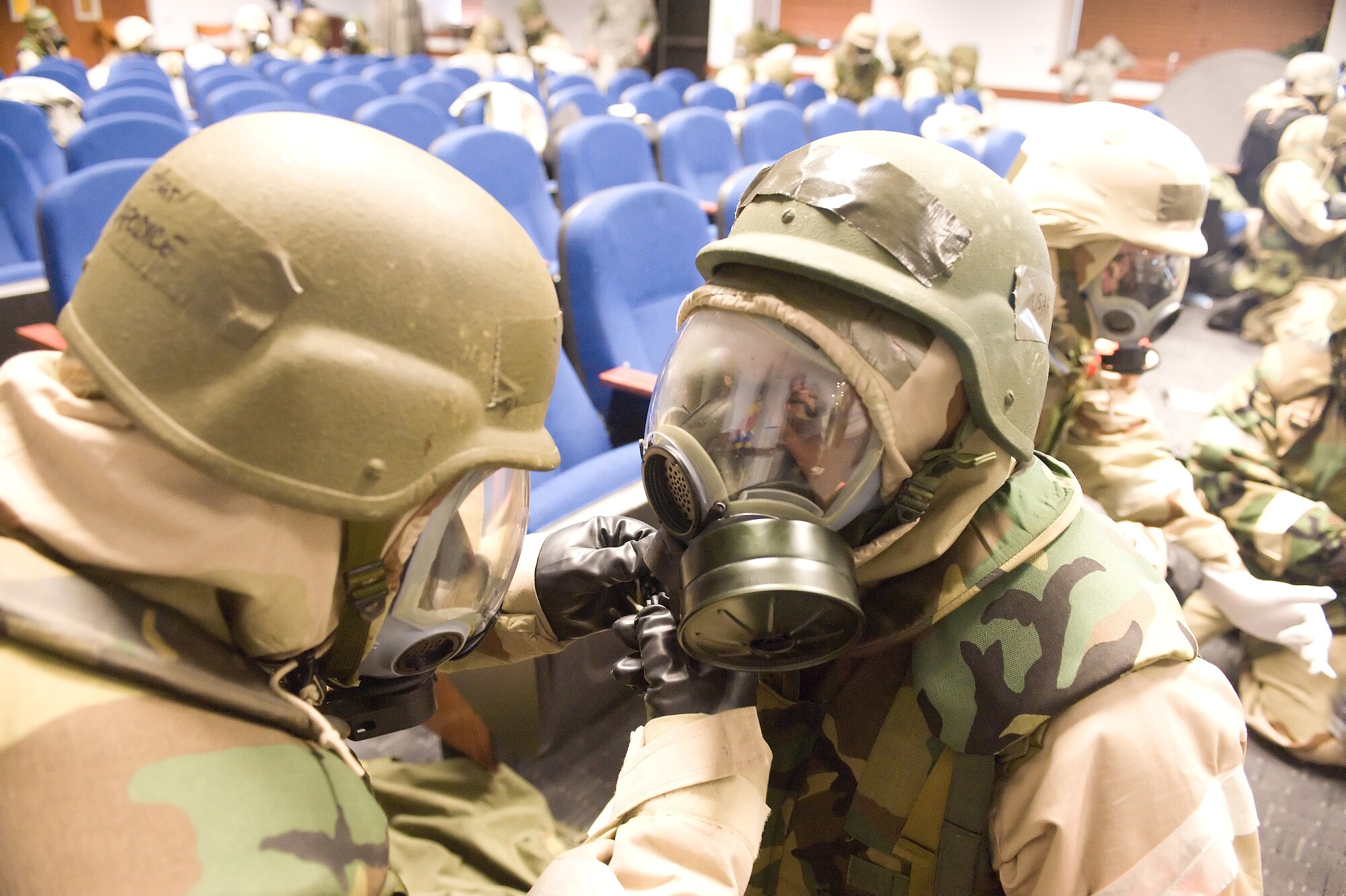 Tech. Sgt. Scott Capodice (left) performs a buddy check on Master Sgt. Paul Hursey during Ability to Survive and Operate training April 20, 2011, at Dover Air Force Base, Del. ATSO stressed the importance of properly donning Mission Oriented Protective Posture gear and the dangers of failing to do so. (U.S. Air Force photo by Steve Kotecki)