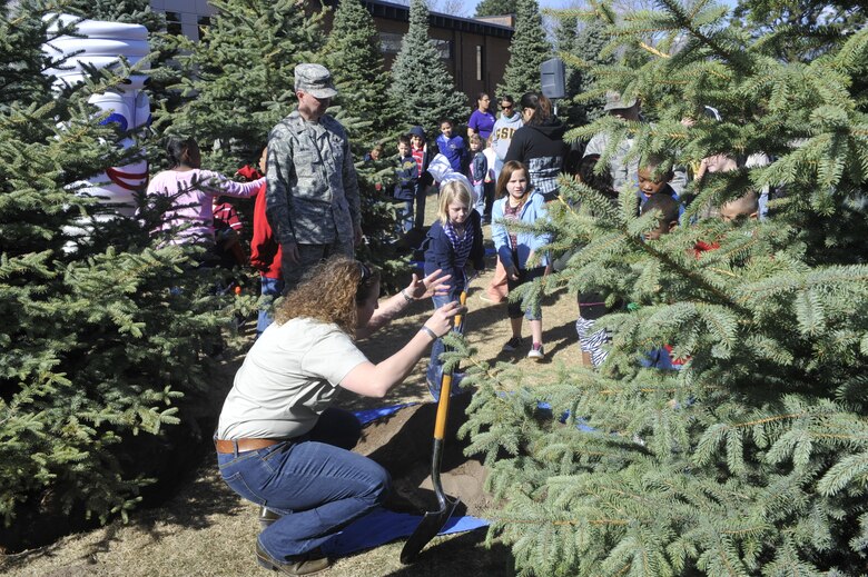 PETERSON AIR FORCE BASE, Colo. – Brenda Wasielewski, from the Colorado State Forest Service, directs children from the Peterson Child Development Center as they take turns shoveling dirt to help plant three new Colorado blue spruce trees at the R.P. Lee Youth Center April 22, 2011 in celebration of Earth Day and Arbor Day. Col. Stephen N. Whiting, 21st Space Wing commander, accepted a “Tree City USA Award” for Peterson Air Force Base’s Tree City USA status, which it earned for its forestry program. Peterson AFB has been a Tree City USA since 1994. Colonel Whiting thanked the 21st Civil Engineer Squadron for its work on the base forestry program and called Peterson a flagship base in the Air Force. The 21st Space Wing celebrated Earth Day with a number of events including a trash pickup, energy awareness booths at the BX, and a youth poster contest. (U.S. Air Force photo/Robb Lingley)