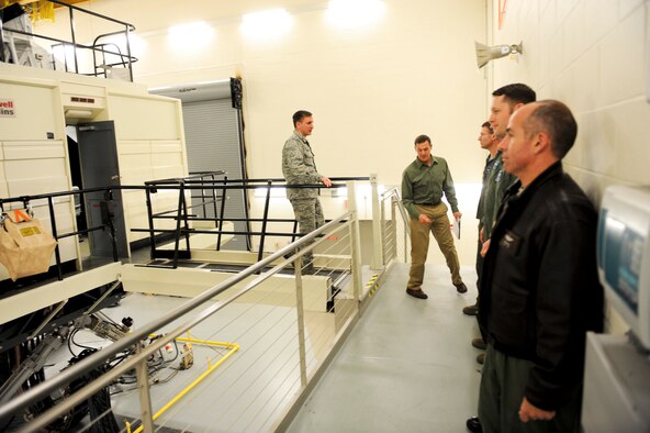 (Left) Col. Jeffrey Taliaferro, 28th Bomb Wing commander, is escorted out after touring the the newly upgraded 18.4 million dollar B-1 simulator April 13, 2011, at Ellsworth Air Force Base. The upgrade improved the simulator in areas such as radar, target pod imagery, weather and high detail air field model.  (U.S. Air Force photo/Senior Airman Adam Grant)