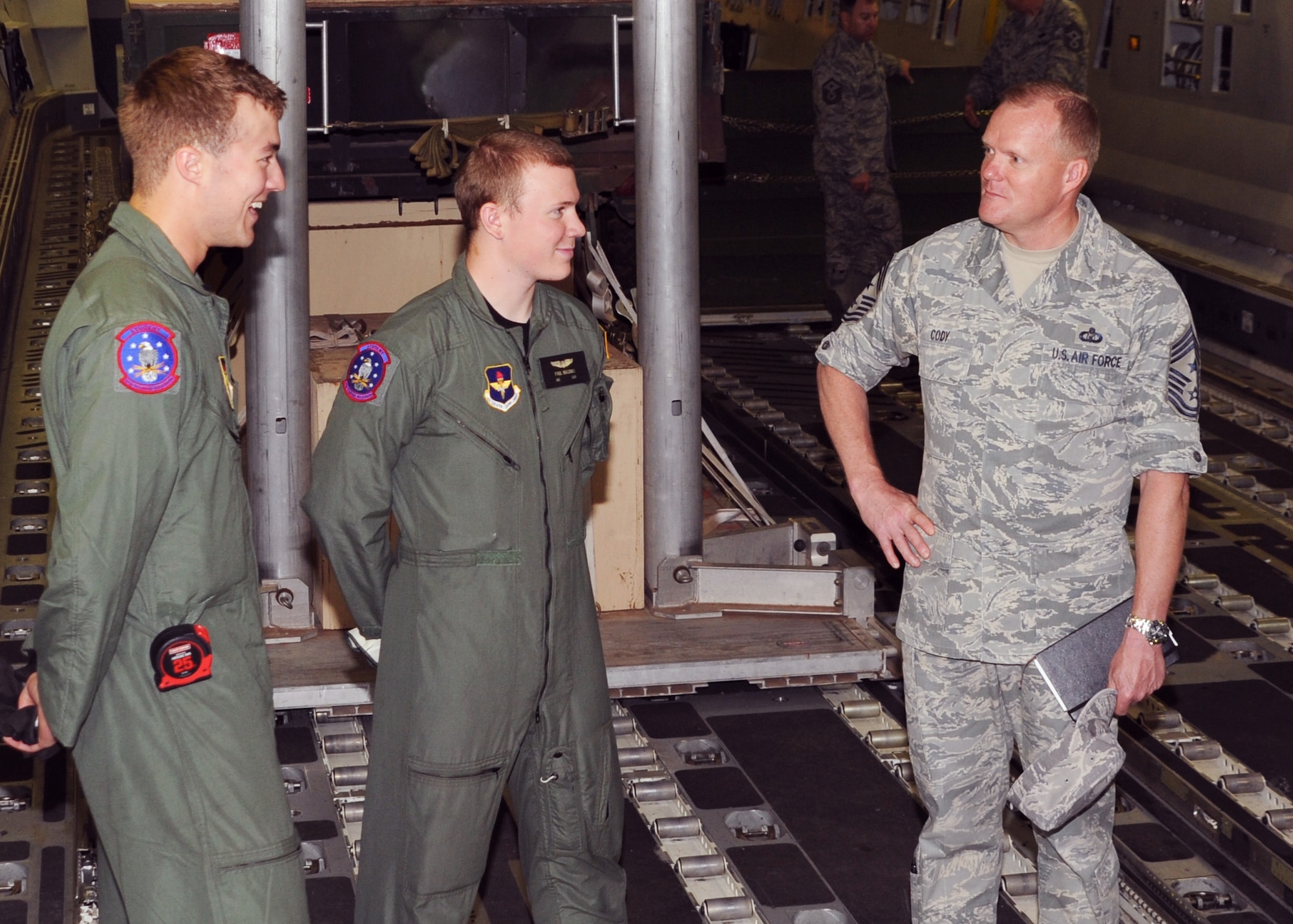 ALTUS AIR FORCE BASE, Okla. -- Airmen 1st Class Brandon Patterson and Paul Maginnis, 97th Training Squadron loadmaster students talk, with Chief Master Sgt. James Cody, command chief of Air Education and Training Command, about their training at the C-17 Cargo Load Trainer here April 22. Chief Cody visited various squadrons around the base, spoke with Airmen about their jobs and encouraged them to get to spend at least 90 seconds a day getting to know someone in their workplace. (U.S. Air Force photo by Airman 1st Class Kenneth W. Norman/ 97th Air Mobility Wing Public Affairs)