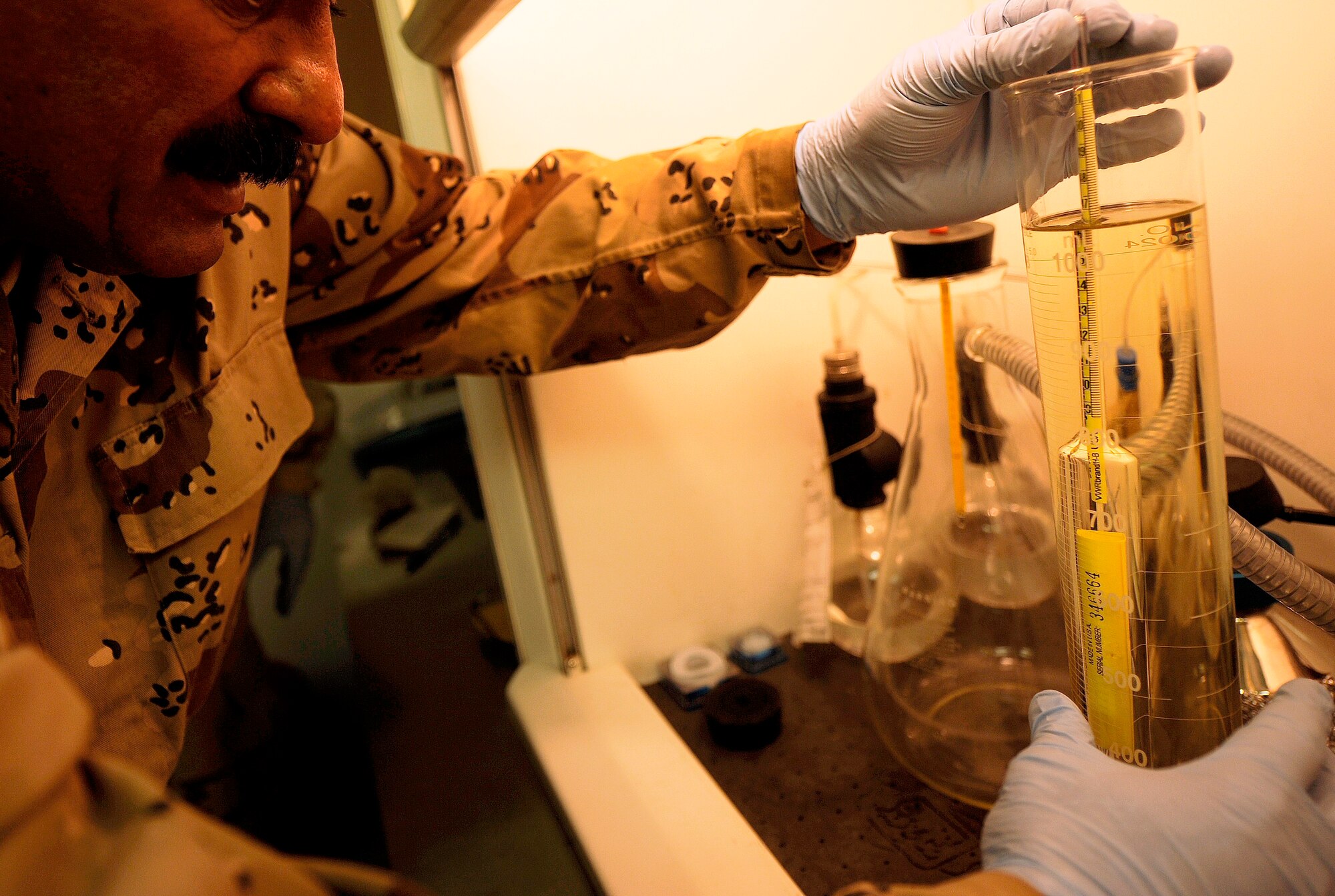 KIRKUK REGIONAL AIR BASE, Iraq -- An Iraqi warrant officer tests jet fuel samples with guidance from Tech. Sgt. Ryan Smith (not pictured). Sergeant Smith has been advising his Iraqi counterparts for more than a month to prepare them for autonomous operations after U.S. military forces transition out. (U.S. Air Force/Tech. Sgt. Jason Lake)