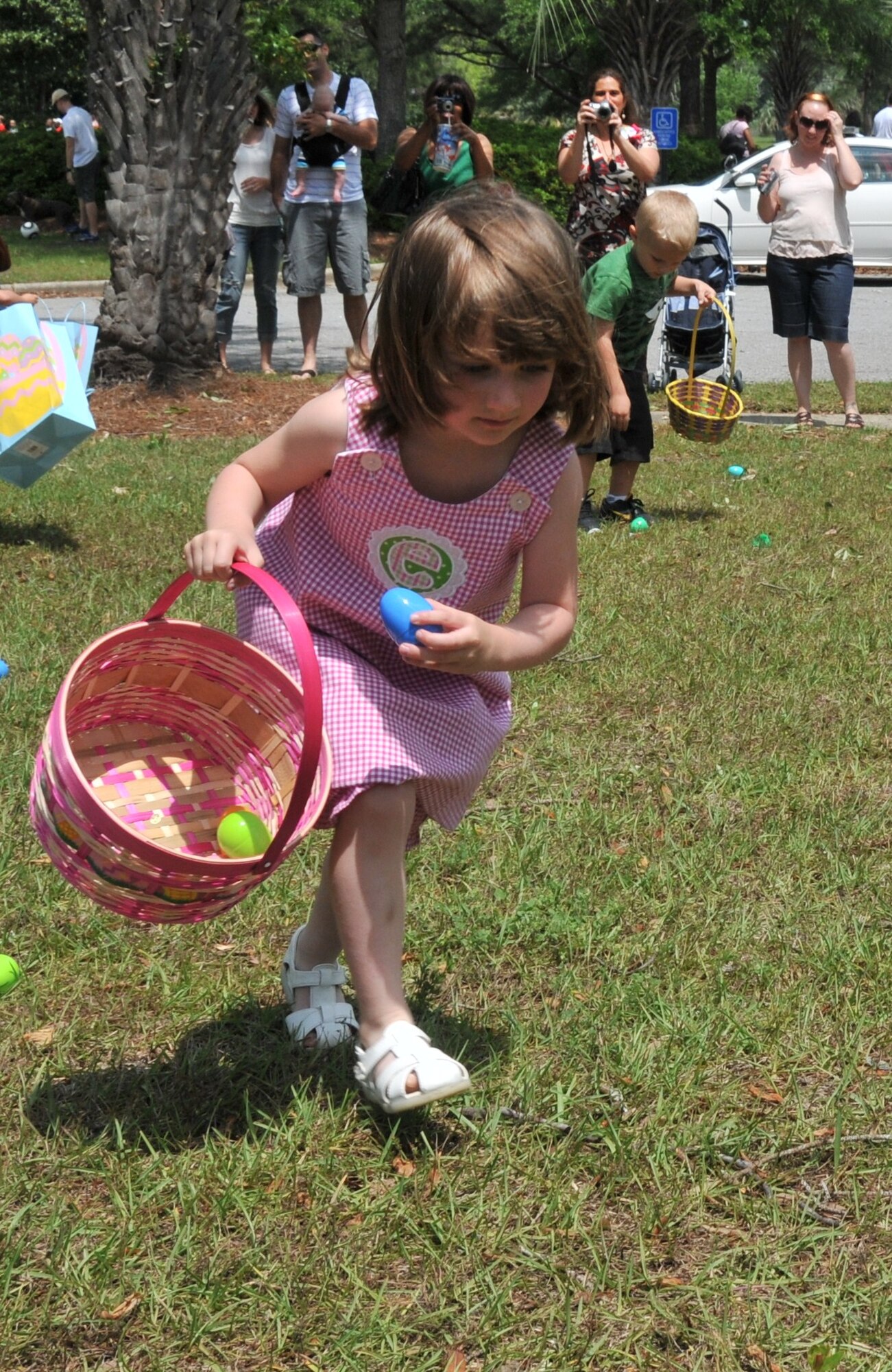 Four-year-old Emma Strealy, daughter of Alan Strealy, a Marine staff sergeant, puts an Easter Egg into her pink basket during an Easter Egg Hunt as part of the Month of the Military Child Festival April 23, on Joint Base Charleston - Air Base. After the Easter Egg Hunt, children enjoyed free games, food and prizes. (U.S. Air Force photo /Airman 1st Class Jared Trimarchi)
