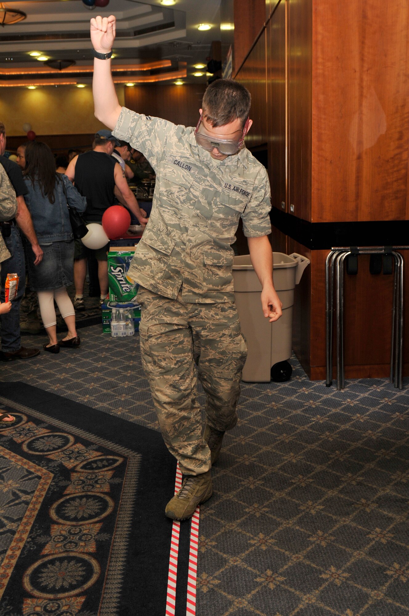 SPANGDAHLEM AIR BASE, Germany – Senior Airman Nathanael Callon, 52nd Fighter Wing Public Affairs, tries to walk a straight line while wearing “drunken goggles” as part of a 52nd FW Safety demonstration at the Operation Odyssey Dawn Bash here April 22. The event was hosted to thank service members and their families for all their hard work and support during Operation Odyssey Dawn. (U.S. Air Force photo/Airman 1st Class Brittney Frees)