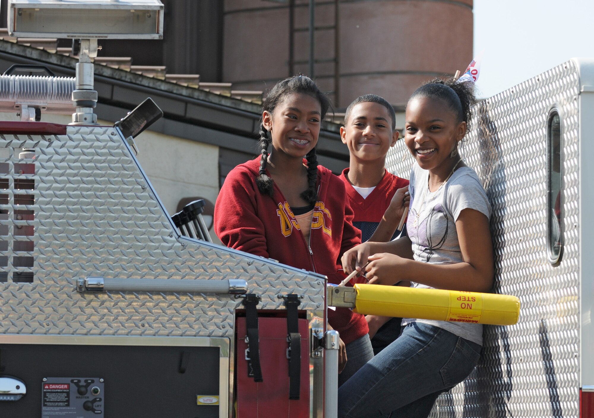 SPANGDAHLEM AIR BASE, Germany – Spangdahlem Middle School seventh grade students Christinna Pinkney, left, Shawn Robinson, center, and De’Ja Knight, right, stand on top of a 52nd Civil Engineer Squadron fire truck during Spangdahlem Middle School’s Earth Day fair here April 21. Companies and organizations visited the school to teach students about the local environment, wildlife and how to conserve natural resources. (U.S. Air Force photo/Airman 1st Class Matthew B. Fredericks)