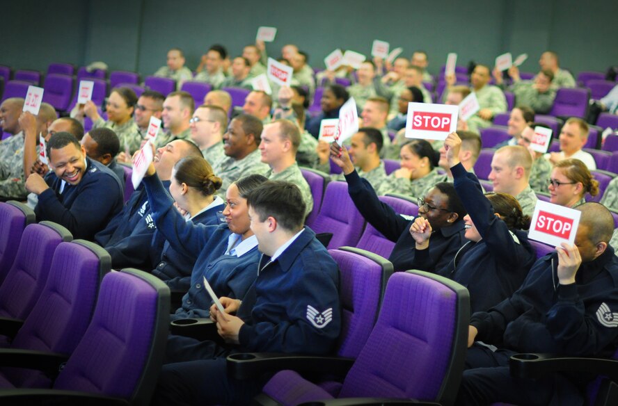 A group of Airmen hold up "stop" signs for a skit during the performance of the show, "Sex Signals" at Osan's base theater April 25. "Sex Signals" presents a series of various dating scenes performed by professional actors who bring realistic circumstances to life and allow Airmen to learn about sexual assault in a "lively and humorous" way. In some cases talking about very serious subject matter. (U.S. Air Force photo/Staff Sgt. Chad Thompson)