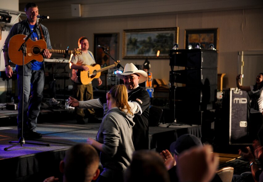 KUNSAN AIR BASE, Republic of Korea -- Darryl Worley, a U.S. country singer, entertains a crowd of more than 250 Wolf Pack Airmen as Chief Master Sgt. James Sanders, 8th Fighter Wing command chief, dances with a fellow country enthusiast and member of the pack at the Loring Club here April 23. Mr. Worley visited to show his appreciation for everything Kunsan does to ensure he and his family stays safe. (U.S. Army photo/Spc. Chris Wellner)