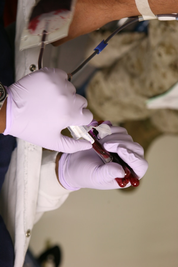 A doctor from The Blood Center fills viles of blood donations at Marine Forces Reserve, April 26.  The donations will be spread out to hospitals around the gulf region.