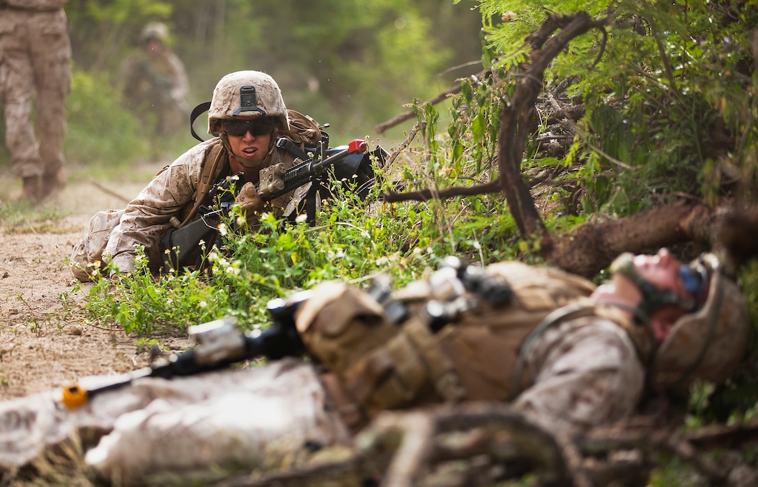Lance Cpl. Jacob Tidwell, a radio operator with India Company, 3rd Battalion, 3rd Marine Regiment, crawls toward simulated casualty Lance Cpl. Chad Winchell, squad leader, India Co., 3/3, during counter-improvised explosive device training at Marine Corps Training Area Bellows, Hawaii, April 26, 2011. The training was part of a two-week evolution that allowed 3/3 Marines to learn and practically apply counter-IED techniques under the watchful eye of instructors from the Marine Corps Engineer Center of Excellence. During mounted and dismounted patrols, MCEC instructors introduced simulated IED explosions, small arms fire and casualty scenarios in order to guide the Marines how to mitigate the threat of IEDs, and respond to their detonation.