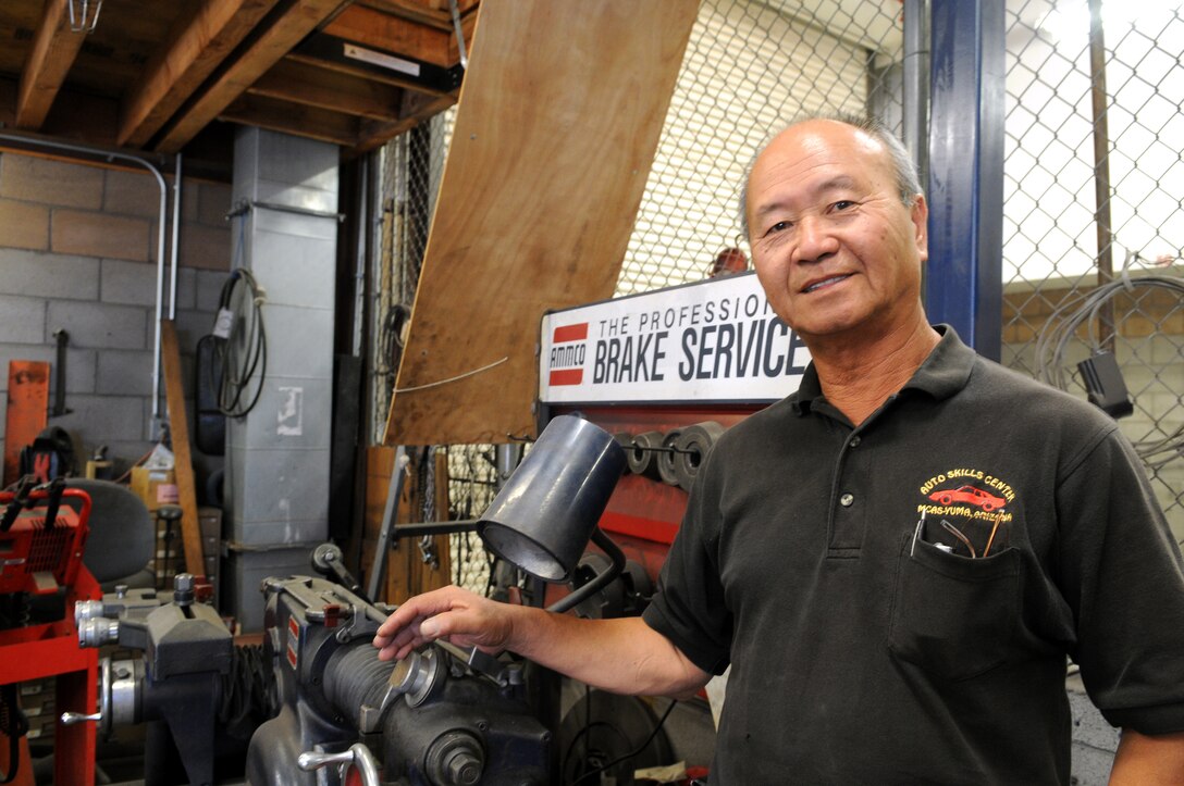 King Wong poses next to machinery in the Marine Corps Air Station Auto Hobby Shop April 26, 2011. After 16 years as the shop's manager, Wong's auto hobby center was recognized as one of the best auto shops in the Corps before he retires July 15, 2011. "He has done a lot of innovative things at the hobby shop, far above what is expected of him. We really hate to see him go. The next guy has big shoes to fill," said David Rodriguez, station environmental director.