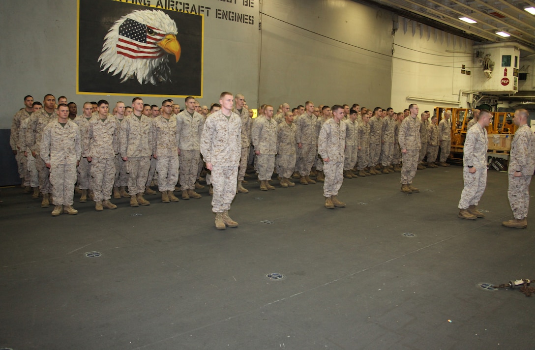 Marines with Fox Company, Battalion Landing Team, 2nd Battalion, 2nd Marine Regiment, 22nd Marine Expeditionary Unit, stand in formation during an awards ceremony aboard USS Bataan April 26, 2011.  Private First Class Jose C. Picena, a rifleman and Pasadena, Texas, native, with Fox Company received a Navy and Marine Corps Commendation Medal with Combat Distinguishing Device for heroic actions while deployed to Afghanistan in support of Operation Enduring Freedom last year. The Marines and sailors of the 22nd MEU are currently deployed with Amphibious Squadron 6 aboard the USS Bataan Amphibious Ready Group and will continue to train and improve the MEU’s ability to operate as a cohesive and effective Marine Air Ground Task Force.  The 22nd MEU is a multi-mission, capable force, with approximately 2,200 Marines and sailors, and comprised of Aviation Combat Element, Marine Medium Tilt Rotor Squadron 263 (Reinforced); Logistics Combat Element, Combat Logistics Battalion 22; Ground Combat Element, Battalion Landing Team, 2nd Battalion, 2nd Marine Regiment; and its Command Element.