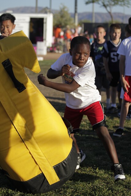 A young participant in the football camp smashes intensely into his bag during drill in a three-day camp run by Chicago Bear Charles Tillman and Dallas Cowboy Kareem Larrimore, April 27, 2011, at Felix Field.::r::::n::::r::::n::