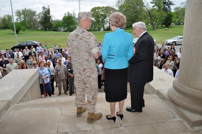 Members of Marine Corps Systems Command witness General James Amos, Commandant of the Marine Corps, presenting Dick and Marguerite Govoni with a coin during an event celebrating Dick’s 60 years of service to the Marine Corps.