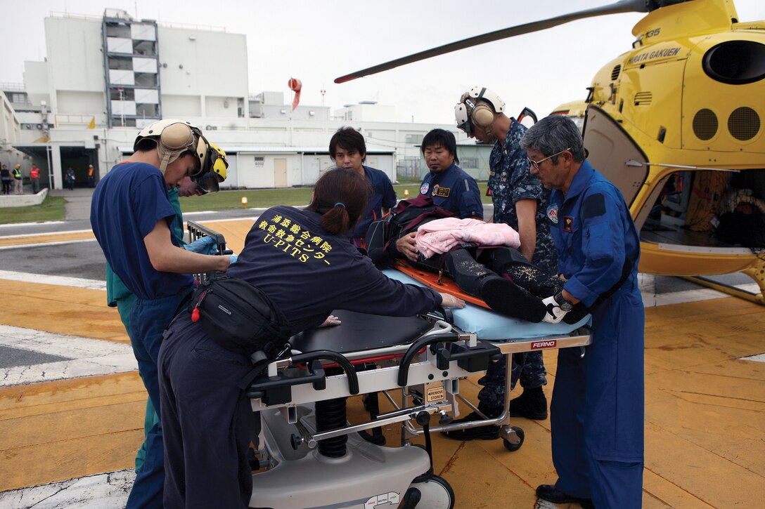 Japanese emergency response team members from Chubu Hospital off-load a mock casualty from the air ambulance, known as “Doctor Heli,” at U.S. Naval Hospital Okinawa April 27. U.S. military and local and national Japanese emergency response services conducted a field training exercise, where, for the first time, Japanese emergency response helicopters performed a patient transport to USNH Okinawa. The exercise was part of an emergency preparedness exercise conducted between the U.S. military and Japanese emergency response services to deepen U.S.-Japan mutual understanding and cooperation.