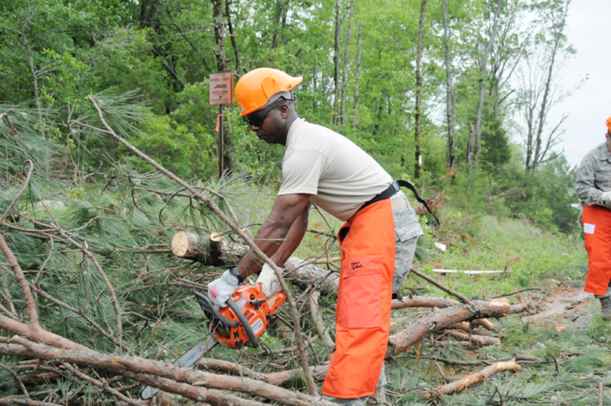 Tech. Sgt. Patrick Williams, a 189th Airlift Wing Rapid Augmentation Team Charlie member and an aerial porter technician, uses a chain saw April 26, 2011, to clear fallen trees blocking roadways after a severe tornado ripped through the small rural community of Vilonia, Ark., April 25. (U.S. Air Force photo by Master Sgt. Dianna Seerey)