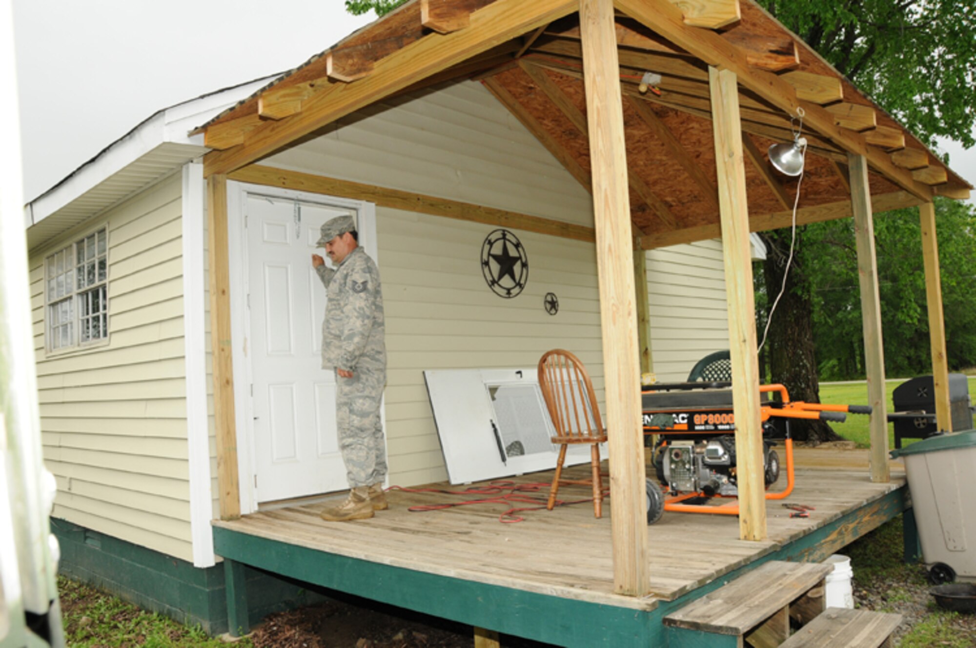 Tech. Sgt. Kevin Burrow, a 189th Maintenance Squadron crew chief, knocks on a Vilonia residents’ door April 26, 2011, during early morning patrols after the small rural community sustained severe damages to homes, powerlines and businesses April 25. Sergeant Burrows is a member of the all-volunteer 189th Airlift Wing’s Rapid Augmentation Team Charlie patrol that checks on residents after severe weather damage. (U.S. Air Force photo by Master Sgt. Dianna Seerey)