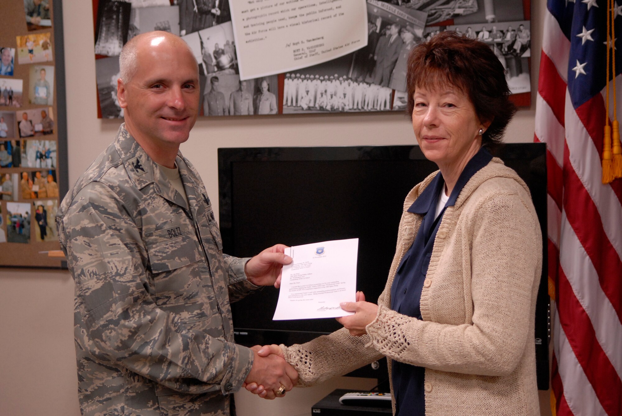 VANDENBERG AIR FORCE BASE, Calif. – Col. Richard Boltz, 30th Space Wing commander, presents Jan Kays, 30th SW Public Affairs graphic artist, with a letter of appreciation for graphic support here Wednesday, April 13, 2011. (U.S. Air Force photo/ Staff Sgt. Andrew Satran) 