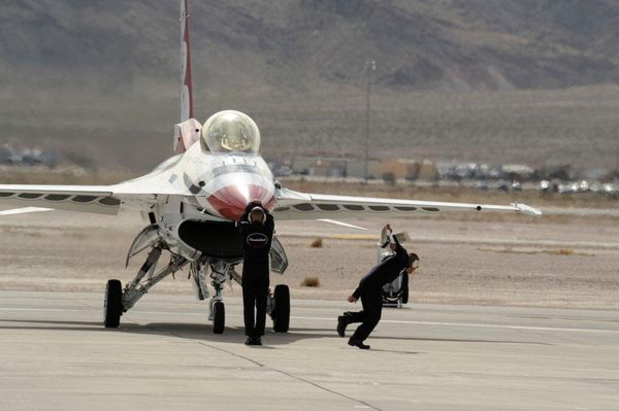 Staff Sgt. Jake Spiller and Tech. Sgt. Jose Hidalgo, U.S. Air Force Air Demonstration Squadron "Thunderbirds” crew members, "catch" Thunderbird #3 after landing at Nellis Air Force Base, Nev., March 10, 2011. The Thunderbirds will headline AirPower over Hampton Roads, Langley AFB's signature air show, May 13-15, 2011. (U.S. Air Force photo/Staff Sgt. Richard Rose, Jr.)