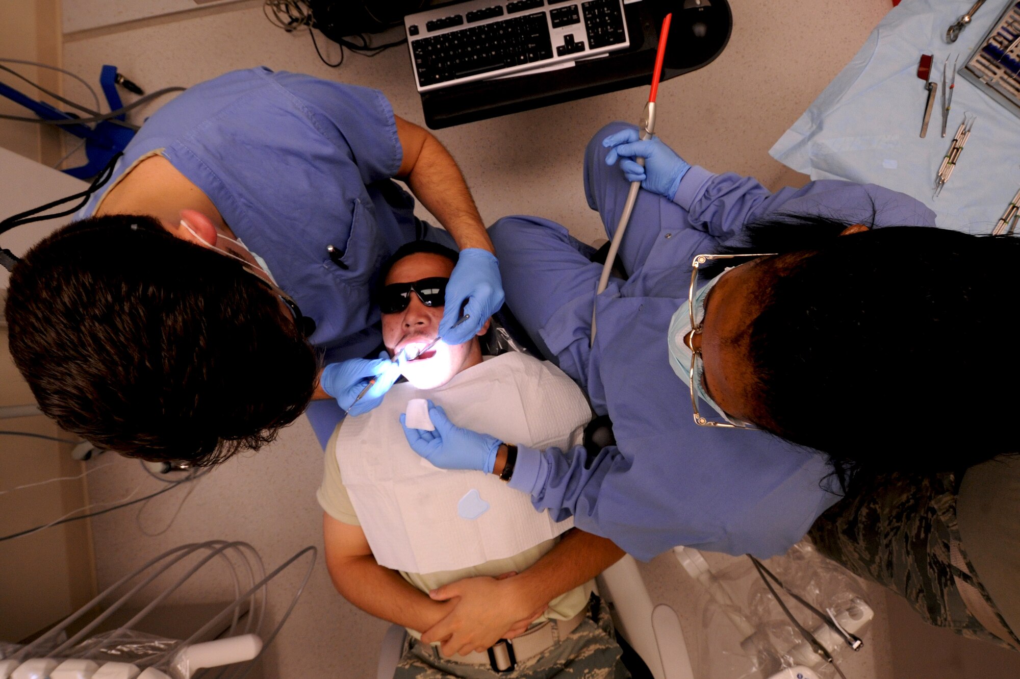 Capt. Stephen Lambert, 23rd Aerospace Medicine Squadron dentist, administers care to a patient as Saundra Pittman, 23rd AMDS dental assistant, assists during the procedure at the 23rd Medical Group Dental Clinic at Moody Air Force Base, Ga., April 27. Routine checkups with the dental clinic will help prevent Moody personnel from oral emergencies by catching dental problems early. (U.S. Air Force photo/Airman 1st Class Benjamin Wiseman)(RELEASED)
