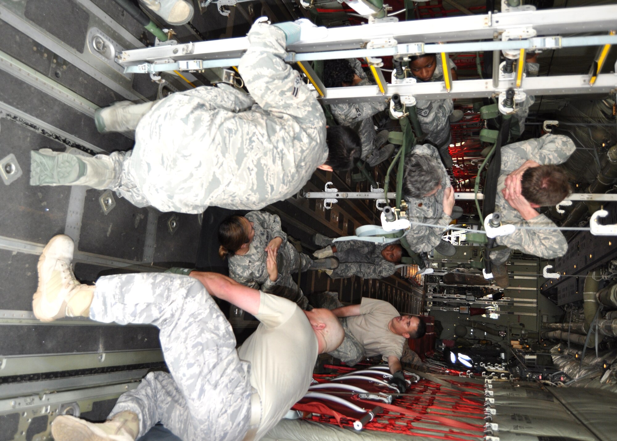 Team leaders Tech. Sgt. Stephen Thackery, 81st Medical Operations Squadron, right foreground, and Master Sgt. Mauricio DeFreitas, 81st Aerospace Medicine Squadron, right background, assist litter-bearers Airmen 1st Class Brent Weber, 81st MDOS, left foreground, and Ana Elena Aguilar, 81st Dental Squadron, secure “patients” during the 81st Medical Group’s April 14 warrior training. Almost 80 medics from a variety of specialties trained to load and unload litter patients on a 403rd Wing C-130J Hercules used by the 815th and 345th Airlift Squadrons. The session also included moving patients on and off an ambulance and a bus. Both Sergeants DeFreitas and Thackery are former aeromedical evacuation trainers. The practice was conducted to prepare for the national-level “Ultimate Caduceus 2011” disaster exercise to be conducted May 16-20. Keesler and area hospitals will be heavily involved May 18.  (U.S. Air Force photo by Steve Pivnick)