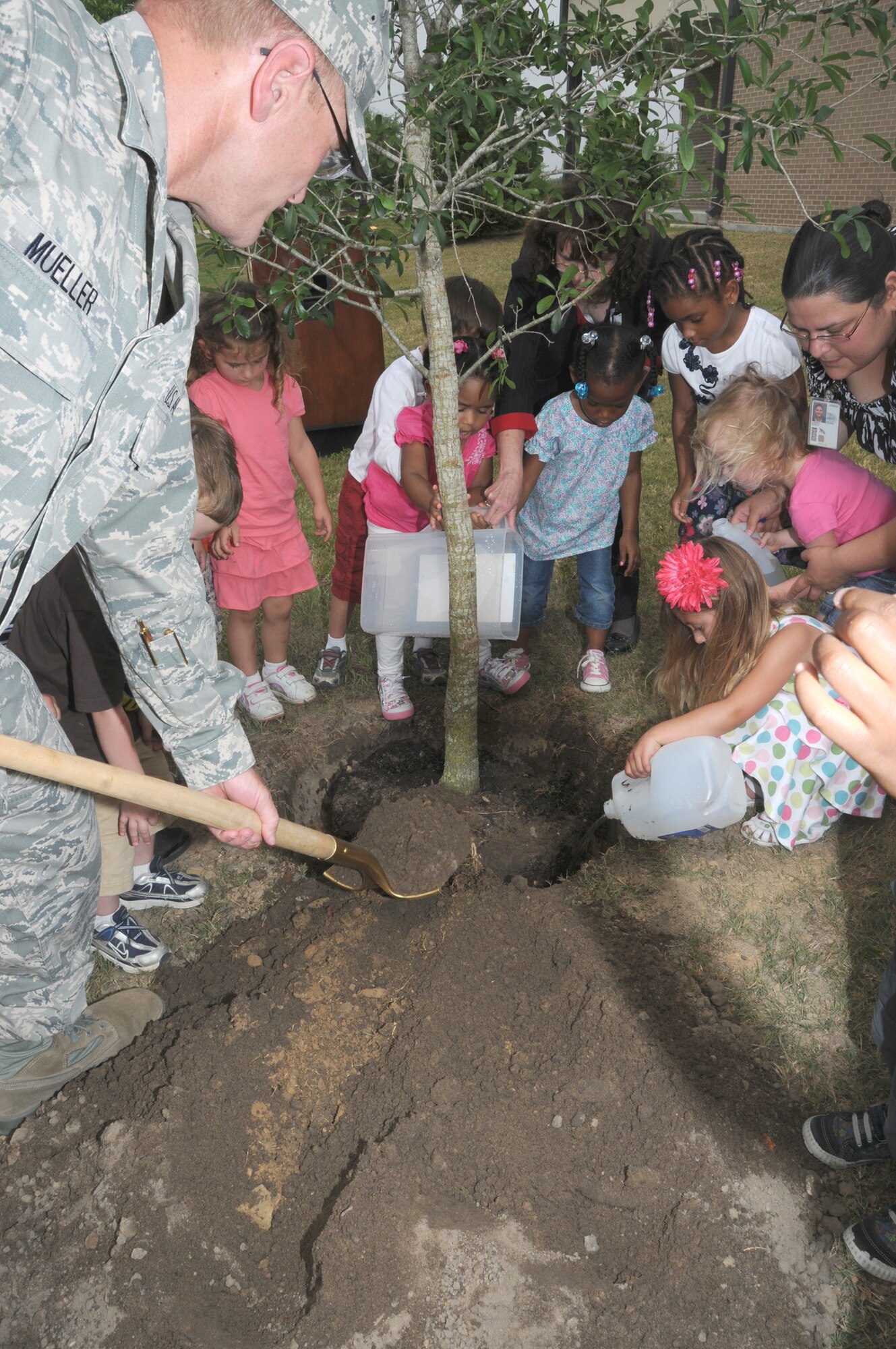 Brig. Gen. Andrew Mueller, 81st Training Wing commander, plants a tree with help from children at the child development center during Keesler’s Earth-Arbor Day observance, April 19.  The base was recognized with the Tree City USA award from the National Arbor Day Foundation for the 18th consecutive year.  (U.S. Air Force photo by Kemberly Groue)