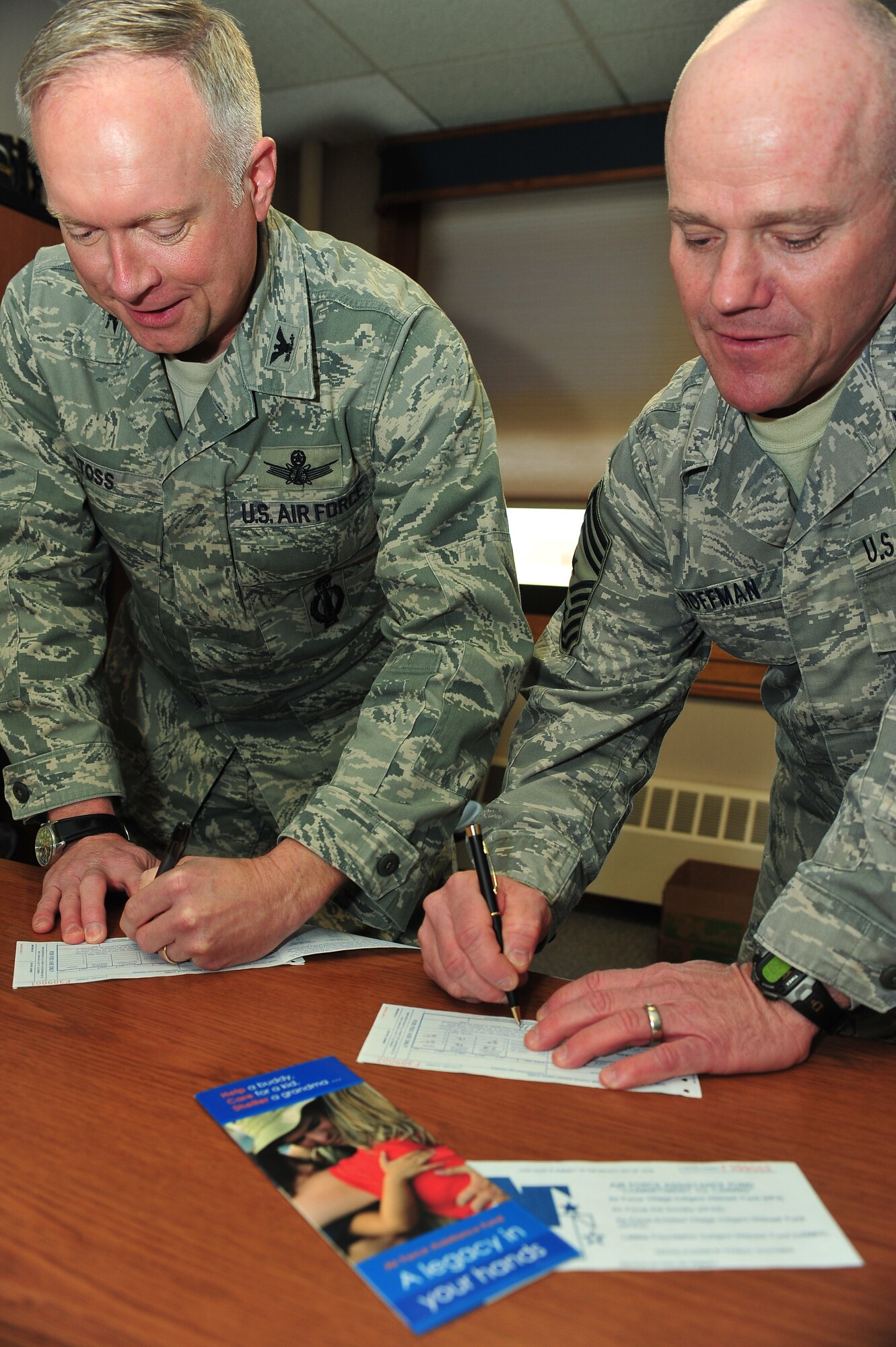 MINOT AIR FORCE BASE – Col. Fred Stoss, 91st Missile Wing commander, and Chief Master Sgt. John Hoffman, 91st MW Command Chief, fill out their forms for the Air Force Assistance Fund here April 21. The AFAF was established to raise funds for the charitable organizations that provide support for active duty, retirees, reservists, guardsmen and their dependents, including surviving spouses in need. (U.S. Air Force photo/Senior Airman Jesse Lopez) 