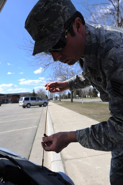 MINOT AIR FORCE BASE N.D. -- Staff Sgt. John Comer, 5th Logistics Readiness Squadron logistics planner, checks the oil in his car here April 25. Checking your oil routinely is a responsible way to keep your car in running condition. (Air Force photo/Airman 1st Class Aaron-Forrest Wainwright)
