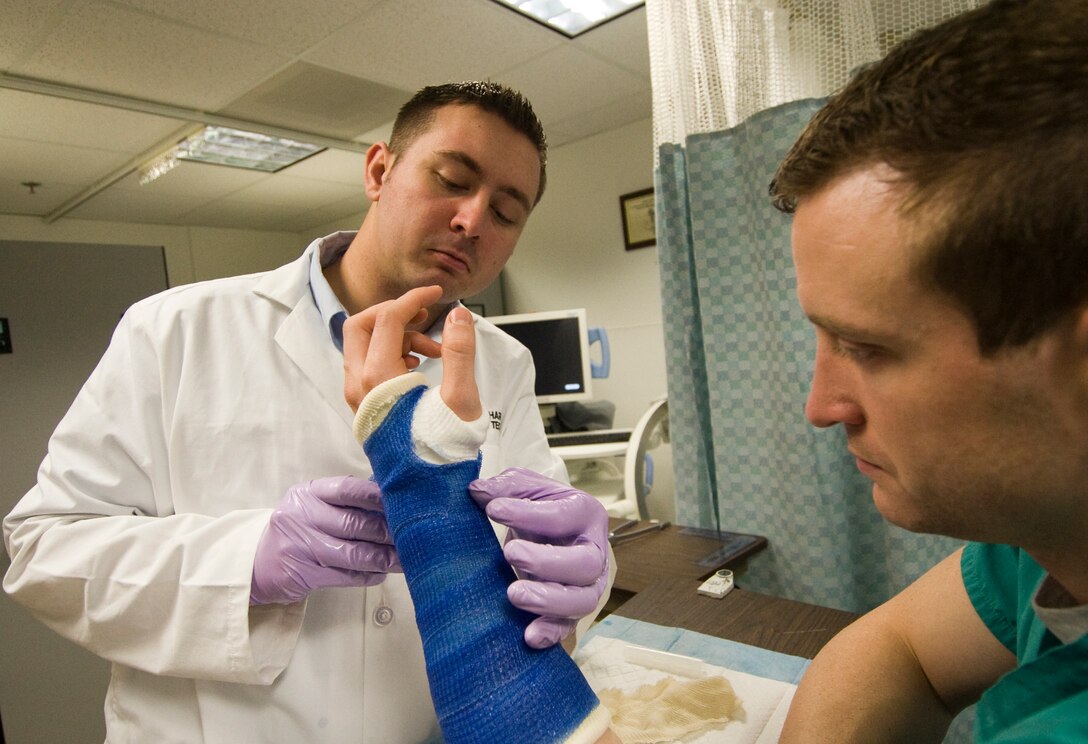 Staff Sgt. Michael Richardson, 779th Surgical Operations Squadron Orthopedic Clinic assistant Non Commissioned Officer In Charge, applies a cast to the wrist of Senior Airman Dane Fisher, 779 SGC orthopedic technician, in the Orthopedic Cast room during a correct cast position training session April 25. (Photo by Bobby Jones)
