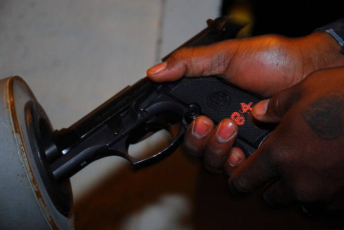 JOINT BASE CHARLESTON, S.C. (April 21, 2011) Master-at-Arms 2nd Class Sherman Whidbee, a patrolman for the 628th Security Forces Squadron, uploads a 9mm weapon into a condition one weapon prior to shift of patrolling the streets of Joint Base Charleston-Weapons Station, April 20. (U.S. Navy photo/Machinist’s Mate 3rd Class Brannon Deugan)
