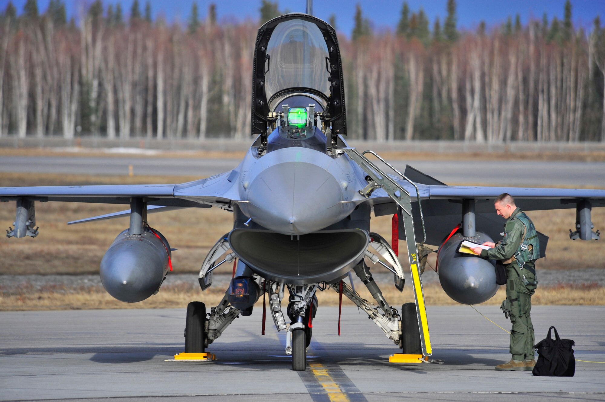 An F-16 Fighting Falcon pilot looks over a checklist prior to a sortie during RED FLAG-Alaska, April 26, 2011, Eielson Air Force Base, Alaska. RF-A provides unique opportunities to integrate various forces into joint, coalition and bilateral training from simulated forward operating bases. The pilot is assigned to the 80th Fighter Squadron, Kunsan Air Base, Republic of Korea. (U.S. Air Force photo/Staff Sgt. Christopher Boitz)