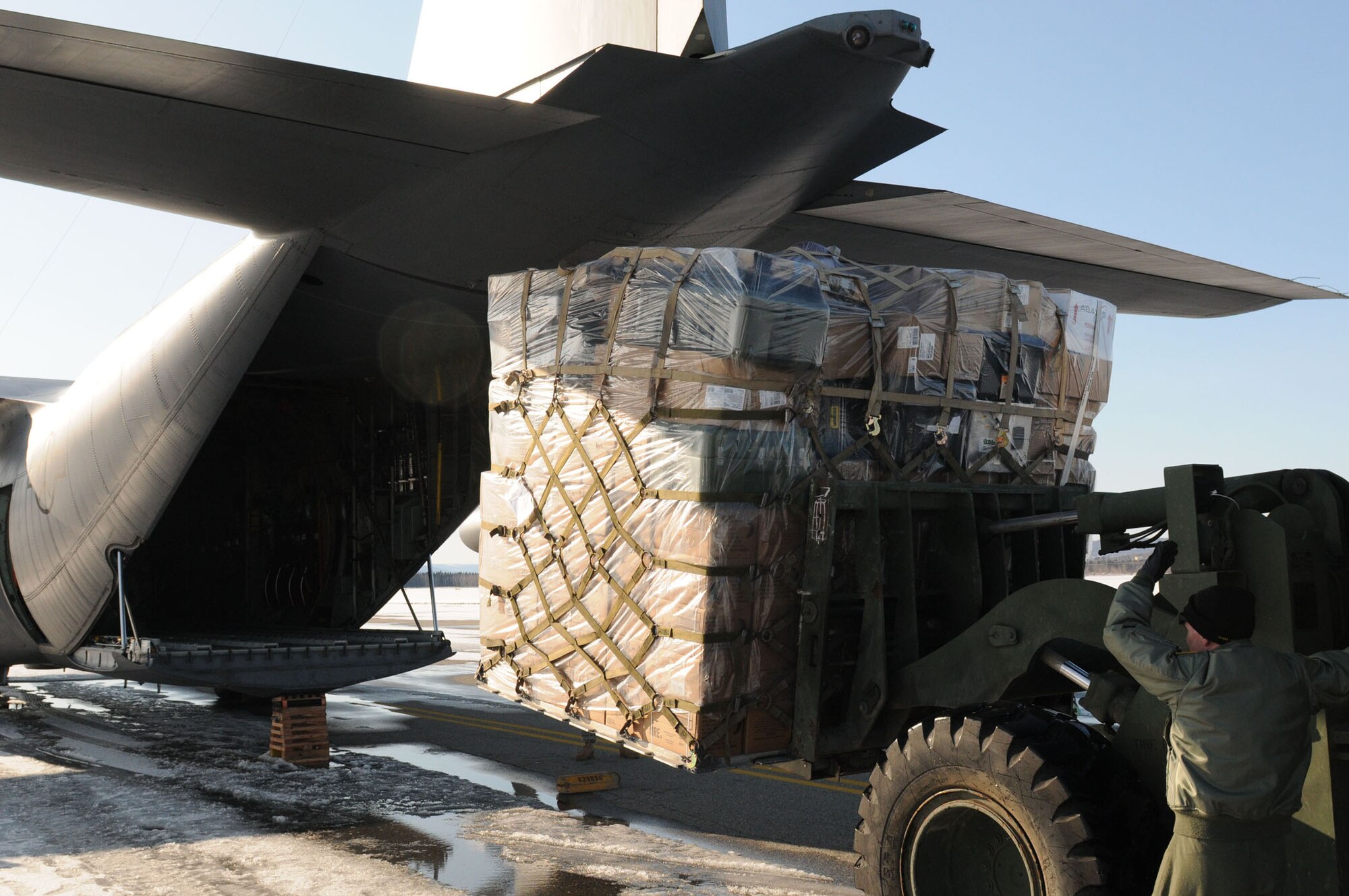 An Alaska Air National Guard loadmaster from the 144th Airlift Squadron guides supplies onto a C-130 Hercules April 14, 2011, in support of Operation Arctic Care 2011. The supplies were destined for a forward logistics base in Galena, Alaska, and will assist medical professionals in providing medical, dental, optometric and veterinary care to Alaskans in remote villages. (U.S. Air Force photo/Lt. Col. Brent Campbell)