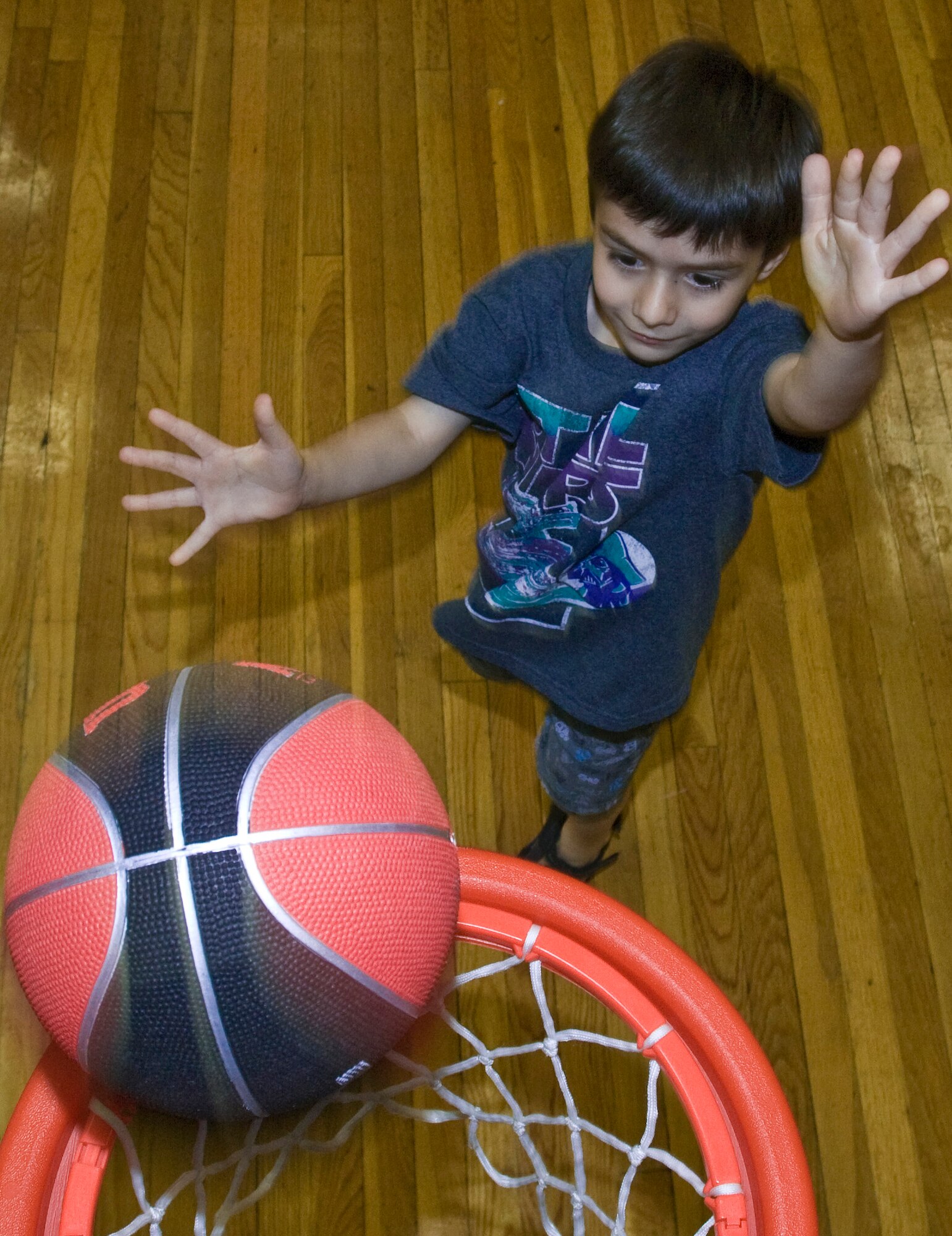 Lucas Savoia, son of 1st Lt. Stefano Savoia, 41st Airlift Squadron, shoots some hoops inside the Thomas Community Activities Center April 23, 2011, at Little Rock Air Force Base, Ark.  The Family Fest event offered food, games, face painting and an egg hunt. (U.S. Air Force photo by Staff Sgt. Nestor Cruz)