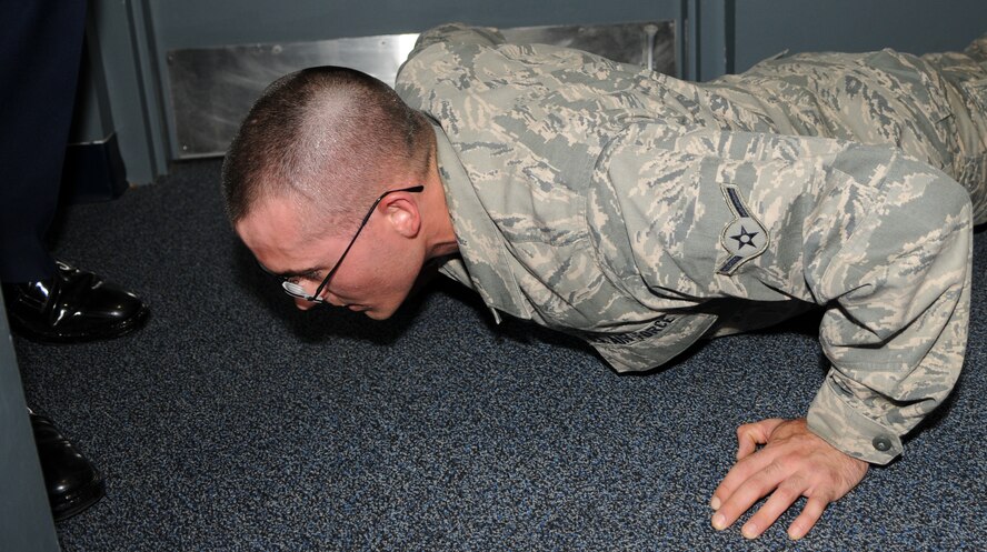 Honor Guard trainee, Airman Chance Stone gets put on his face for failing to move with a purpose April 25, at Joint Base Anacostia-Bolling, Washington, D.C. Upon not correctly following orders or substandard performance honor guard trainees will be disciplined by performing physical activities or extra duties. (U.S. Air Force photo by Senior Airman Christopher Ruano)