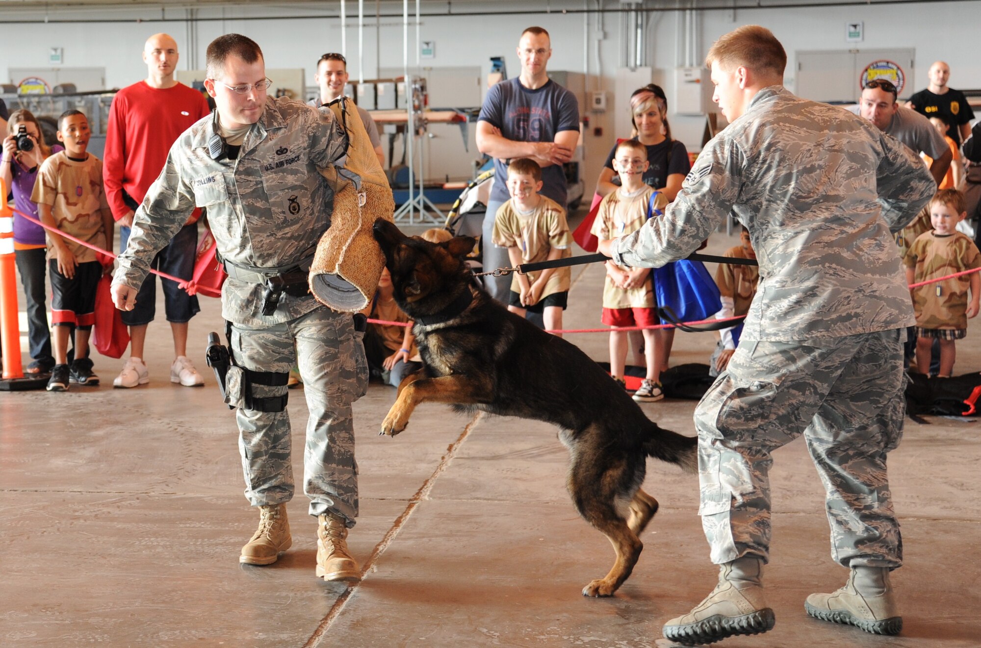 The 82nd Security Forces Squadron military dog handlers do a demonstration for parents and children during Operation KIDS April 23 in hangar 1080. Operation KIDS helps introduce children in military families to the processes their parents go through during deployments. (U.S. Air Force Photo/Airman 1st Class Adawn Kelsey)