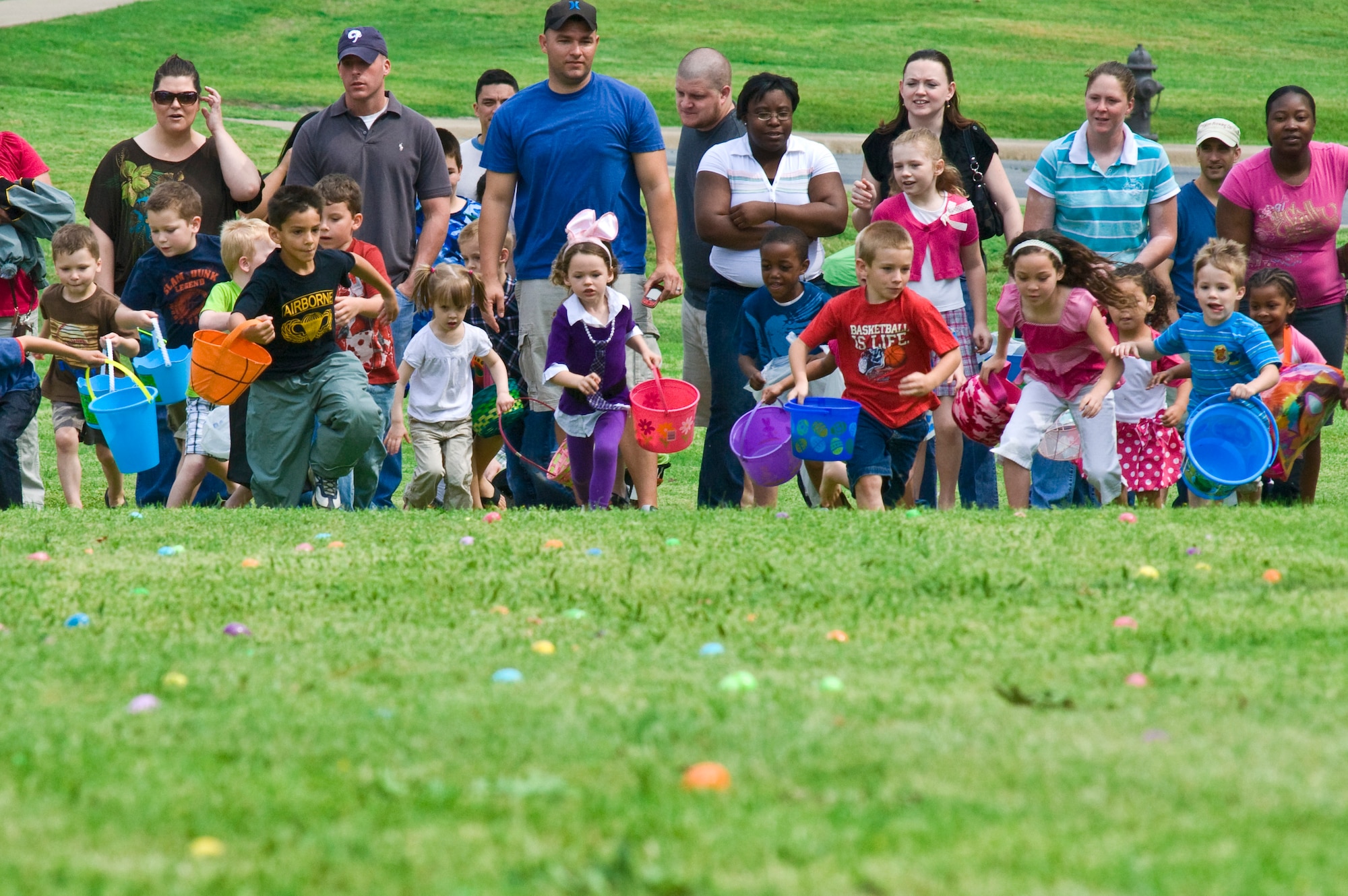 Parents watch as their children scramble for treat-filled plastic eggs during an Easter egg hunt outside the Thomas Community Activities Center April 23, 2011, at Little Rock Air Force Base, Ark.  The Family Fest event offered food, games and an appearance by the Easter bunny. (U.S. Air Force photo by Staff Sgt. Nestor Cruz)