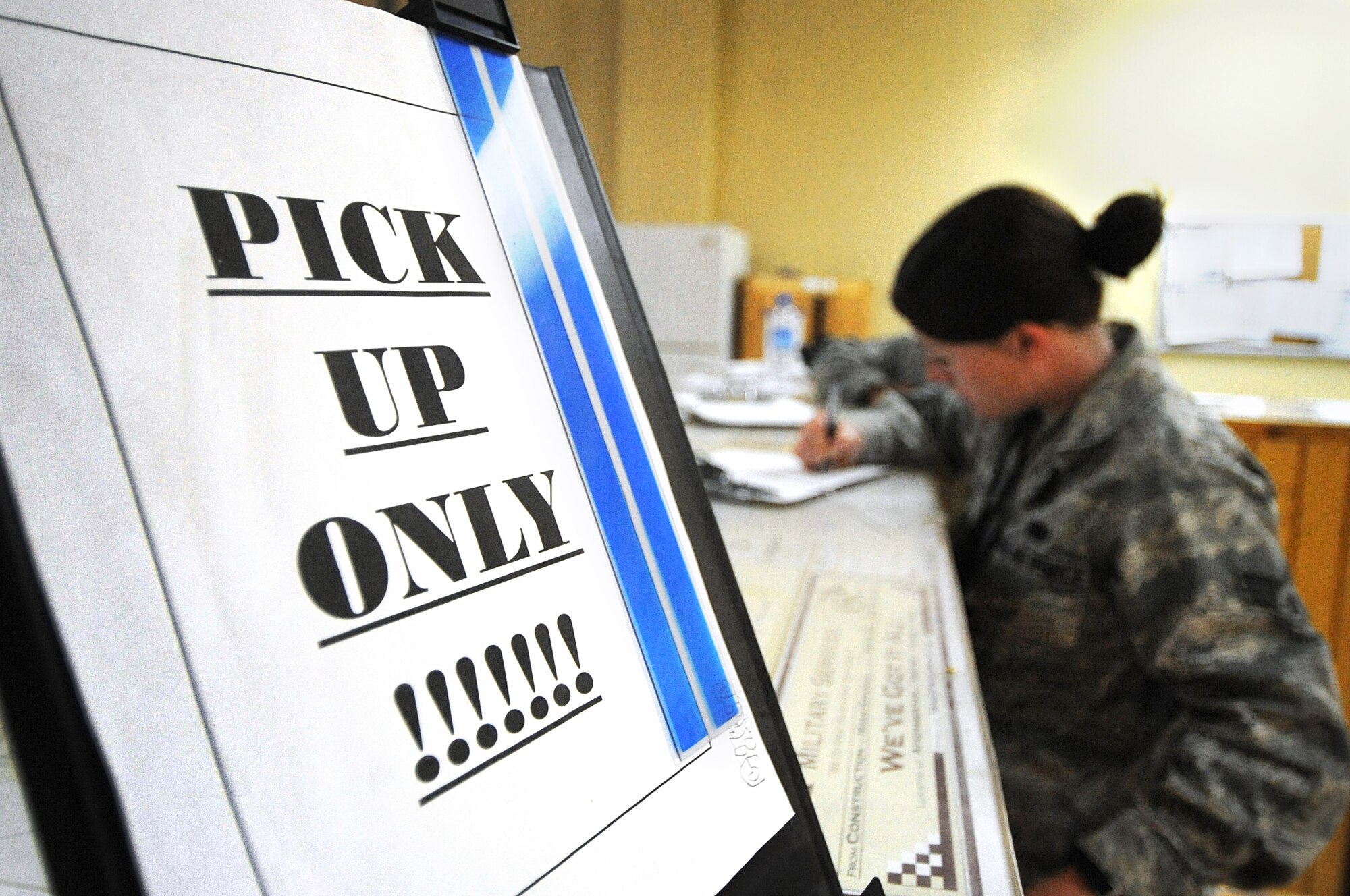 Senior Airman Sara Blake signs in before receiving parts at the local mail service center April 19. About twice a week they pick up shipments of parts and supplies and are continuously building up a foundation for future rotations. Airman Blake works in material maintenance for the HH-60G Pave Hawk engine centralized repair facility and is deployed from Whiteman Air Force Base, Mo. (U.S. Air Force photo by Senior Airman Cynthia Spalding)