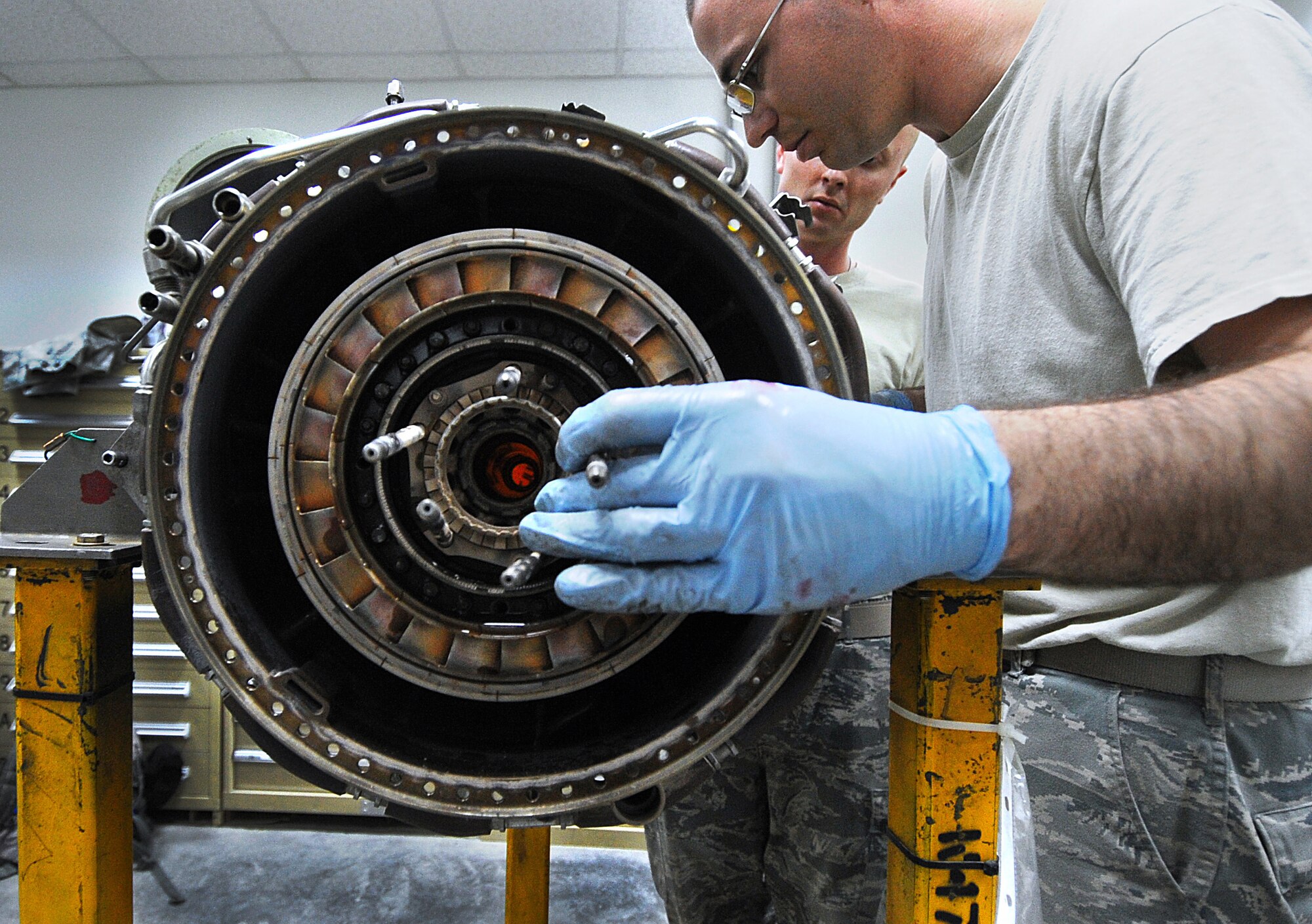 Staff Sgt. Christopher Horton and Senior Airman Craig Styers perform maintenance on an HH-60G Pave Hawk engine that was turned in for low power April 19. Four members of the 386th Expeditionary Maintenance Squadron Detachment 1 stood up the centralized repair facility on an Army base in Southwest Asia, which alleviates the cost and time spent in sending HH-60G Pave Hawk engines back to the United States for maintenance. Sergeant Horton and Airman Styers are aerospace propulsion specialists deployed from Moody Air Force Base, Ga. (U.S. Air Force photo by Senior Airman Cynthia Spalding) 