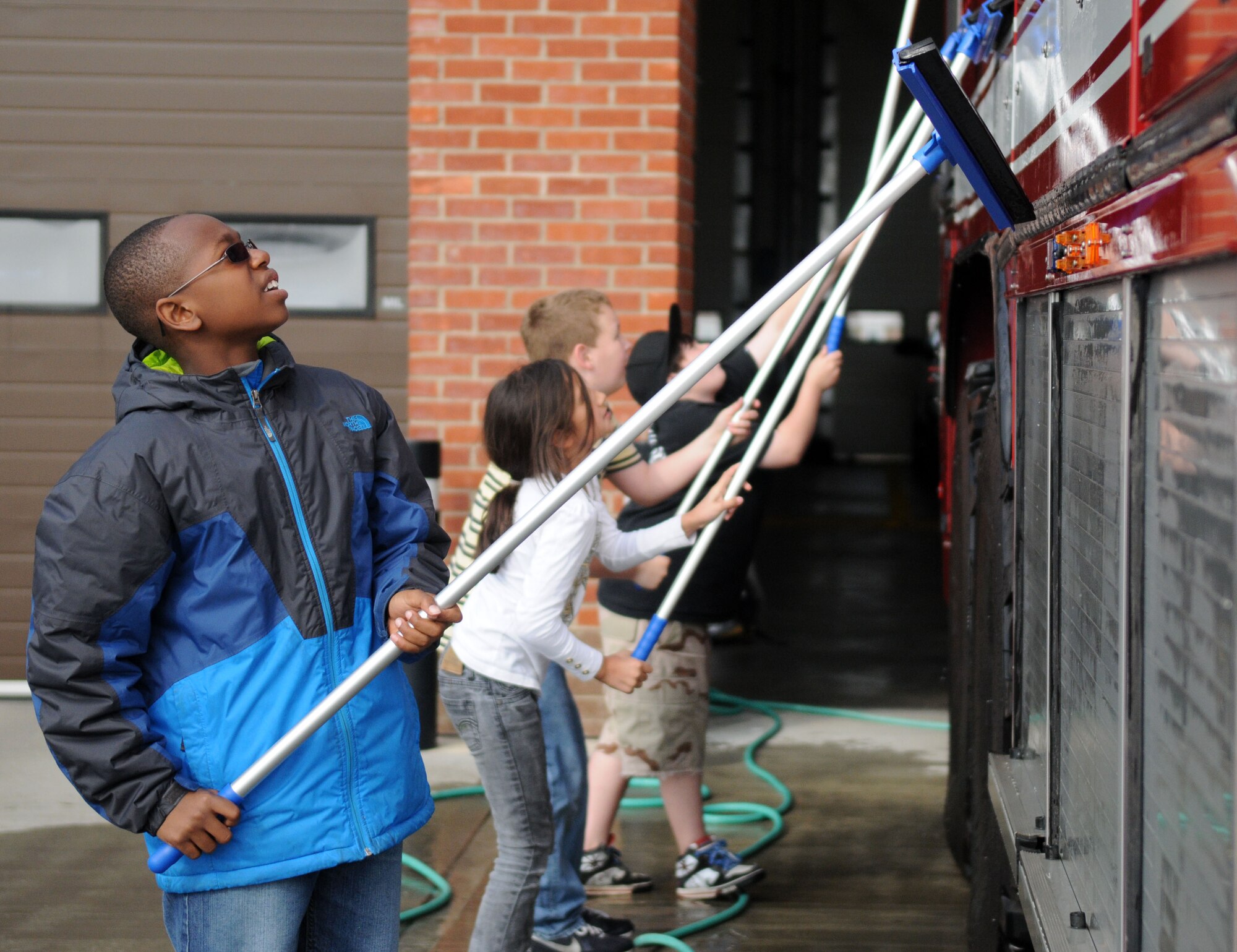 RAF MILDENHALL, England -- Youths from the RAF Mildenhall Youth Center squeegees excess water off of an RAF Mildenhall fire truck during a community service project April 26, 2011, at the fire department. Six children from the youth center had an opportunity to wash a fire truck as part of a monthly community involvement project that gets the youth to interact with the local community and to see different aspects of life on a military base. (U.S. Air Force photo/Airman 1st Class Rachel Waller)