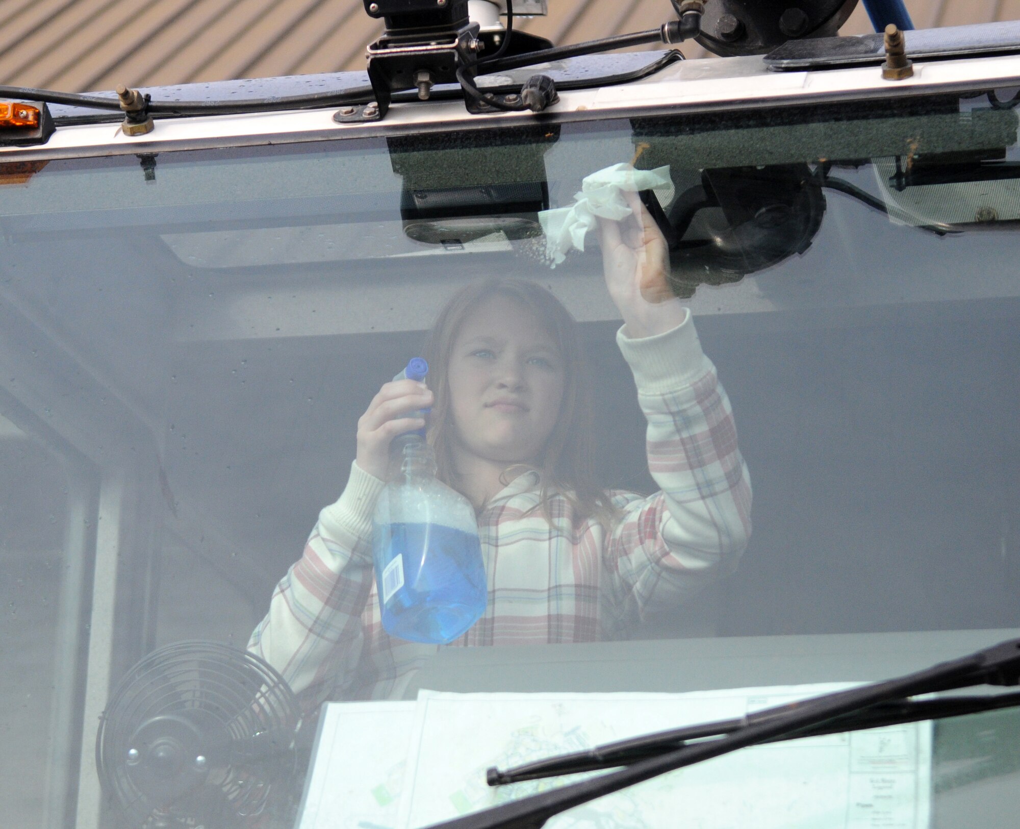 RAF MILDENHALL, England -- Caitlyn Hamberger, daughter of Tech. Sgt. Kathleen Buss, 95th Reconnaissance Squadron, cleans the windshield inside of an RAF Mildenhall fire truck during an RAF Mildenhall Youth Center community service project April 26, 2011, at the fire department. This community service project was part of the youth center?s monthly community involvement project. The purpose of the community involvement project is to get the youth to interact with the local community and to see different aspects of life on a military base. (U.S. Air Force photo/Airman 1st Class Rachel Waller)