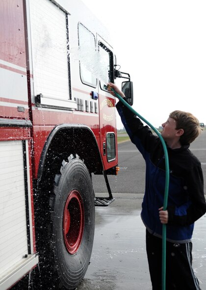 RAF MILDENHALL, England -- Philip, son of Master Sgt. Clinton Slick, 351st Air Refueling Squadron, rinses off an RAF Mildenhall fire truck during an RAF Mildenhall Youth Center community service project April 26, 2011, at the fire department. This project was part of the monthly youth center?s community involvement project. The purpose of the community involvement project is to get the youth to interact with the local community and to see different aspects of life on a military base. (U.S. Air Force photo/Airman 1st Class Rachel Waller)