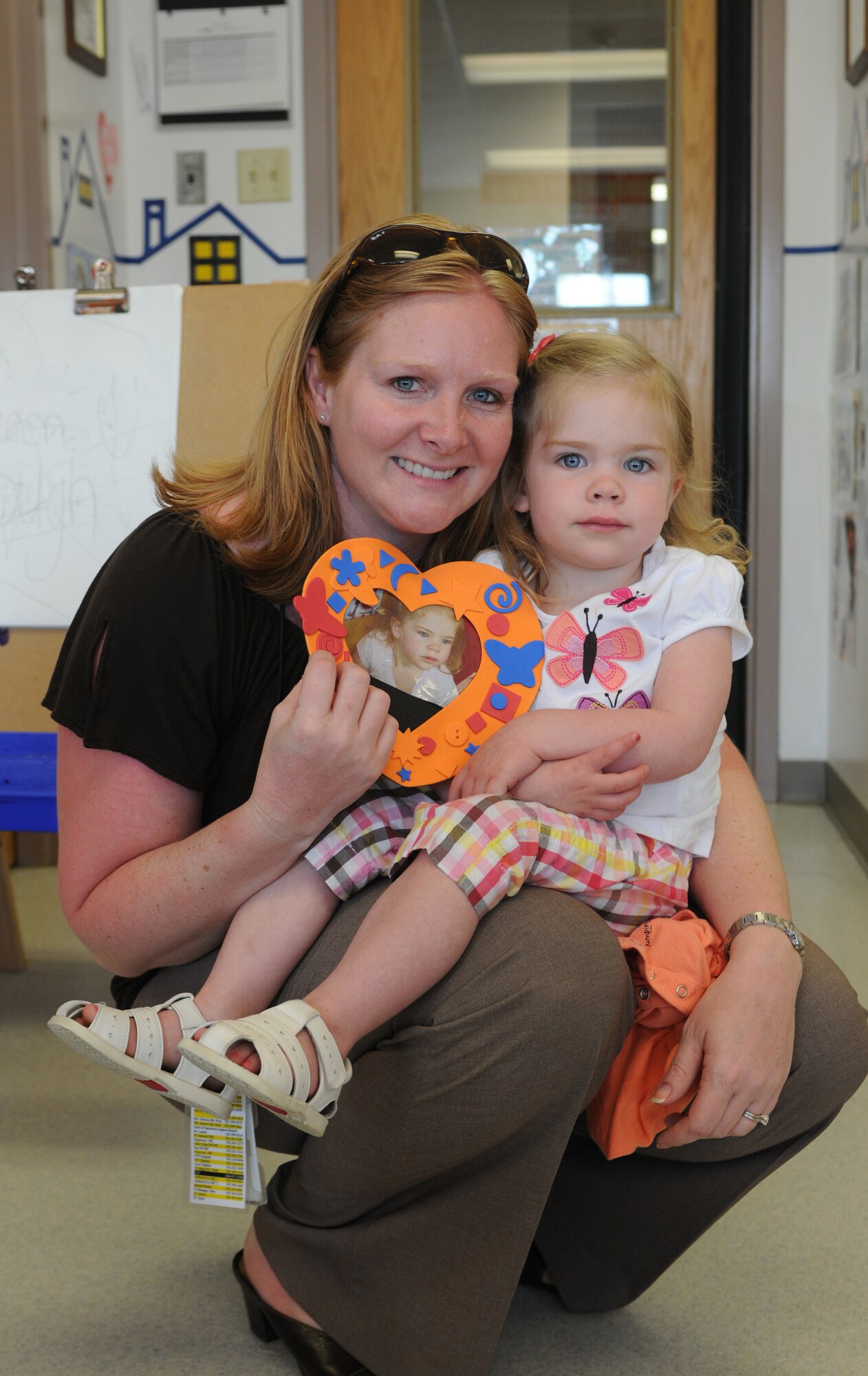 Tech. Sgt. Crhistin Michaud, 512th Force Support Squadron, shows off the picture frame she and her daughter Reagan, 2, put together during a special craft period April 26, 2011, at the Child Development Center, Dover Air Force Base, Del. Moms and dads were encouraged to join their children for craft time as part of the daycare center's Month of the Military Child activities. (U.S. Air Force photo by Master Sgt. Veronica Aceveda/Released)
