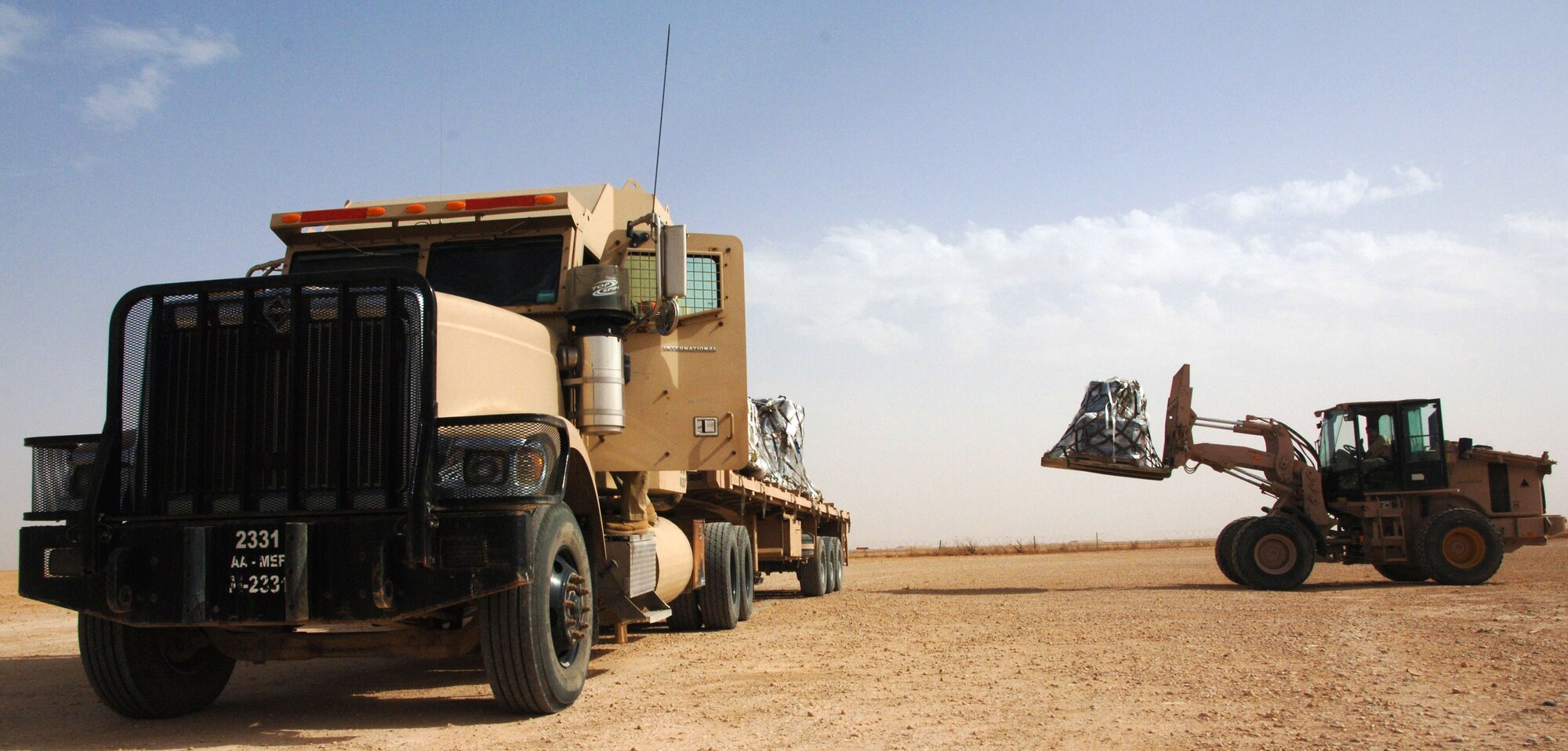 An Airman assigned to the 532nd Expeditionary Operations Support Squadron Air Mobility Flight loads a cargo pallet on to a semi-truck April 20, 2011, at Al Asad Air Base, Iraq. The flight recently took on a commercial cargo mission and made history by unloading its first 747 earlier this month. Since then the aerial porters have offloaded three more 747s, which can hold up to 42 pallets each. (U.S. Air Force photo by Staff Sgt. R. Michael Longoria/Released)
