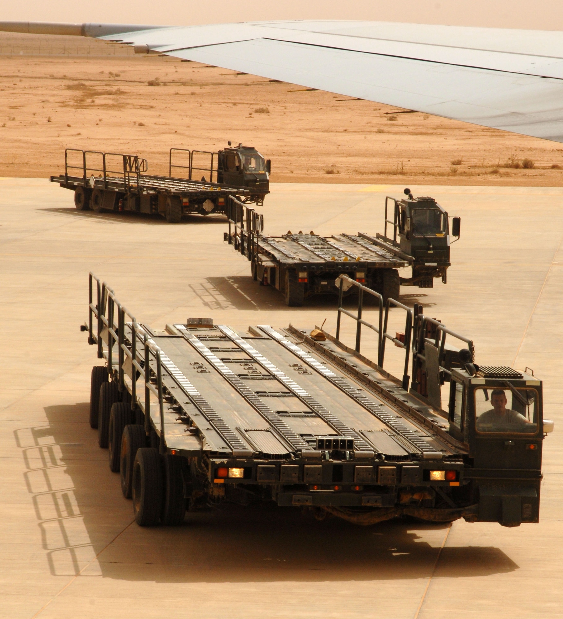 Airmen assigned to the 532nd Expeditionary Operations Support Squadron Air Mobility Flight  line up 60K cargo loaders to offload a commercial 747 April 20, 2011, at Al Asad Air Base, Iraq. The flight recently took on a commercial cargo mission and made history by unloading its first 747 earlier this month. Since then the aerial porters have offloaded three more 747s, which can hold up to 42 pallets each. (U.S. Air Force photo by Staff Sgt. R. Michael Longoria/Released)