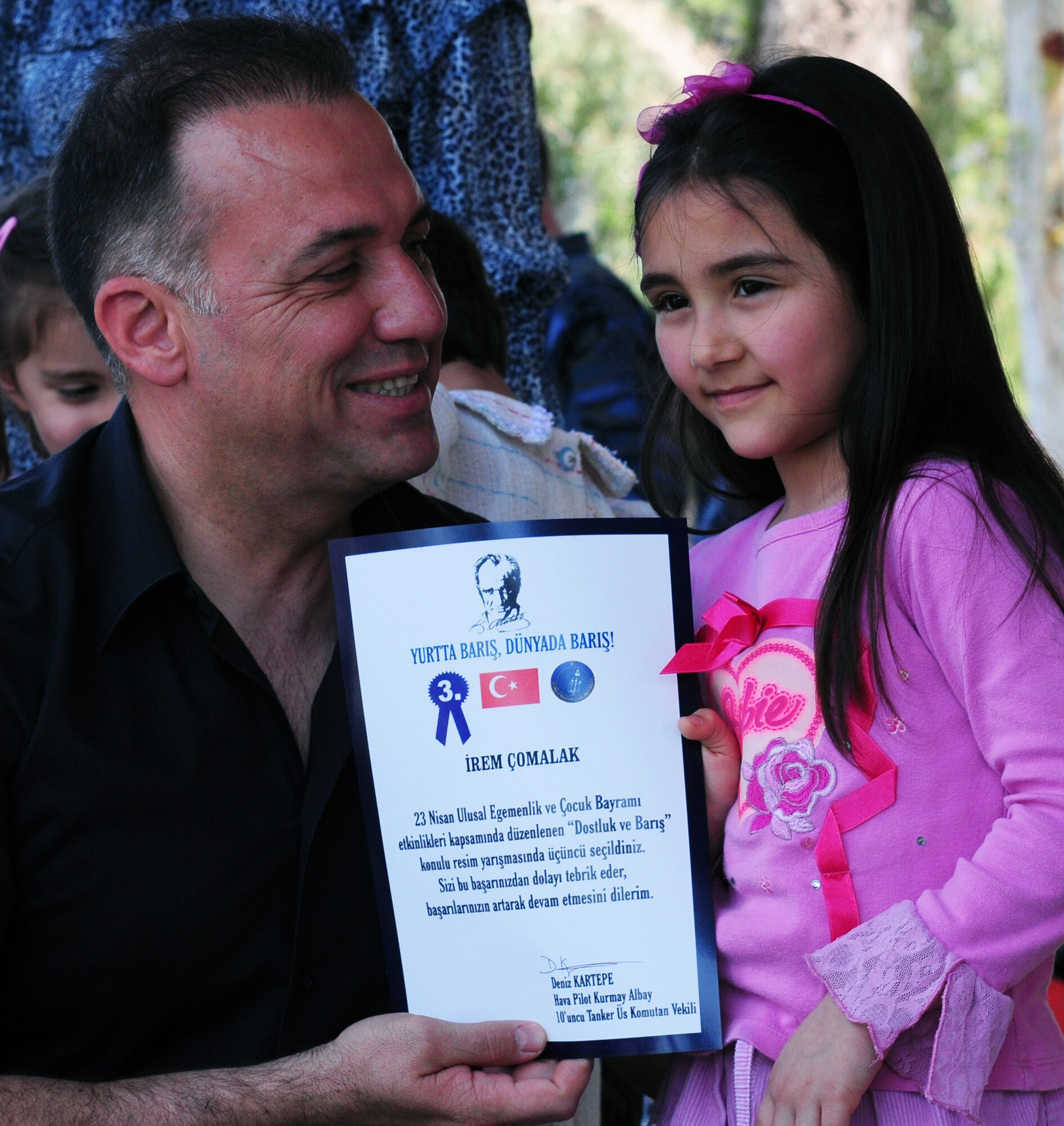 Col. Deniz Kartepe, the commander of the 10th Tanker Command, presents a certificate to a local Turkish child for finishing in 3rd place in the 11-14 age division of an art and poetry contest for National Sovereignty and Children?s Day. Colonel Kartepe presented the award during a Children?s Day festival April 17, 2011, at Incirlik Air Base, Turkey. The event was hosted by the Turkish air force 10th Tanker Command and was open to all Incirlik personnel. The event offered an opportunity for camaraderie and partnership-building for all personnel here, and was a chance to celebrate both Turkish children on their national holiday and military children during the Month of the Military Child, officials said.  (U.S. Air Force photo by 1st Lt. Gina McKeen/Released)