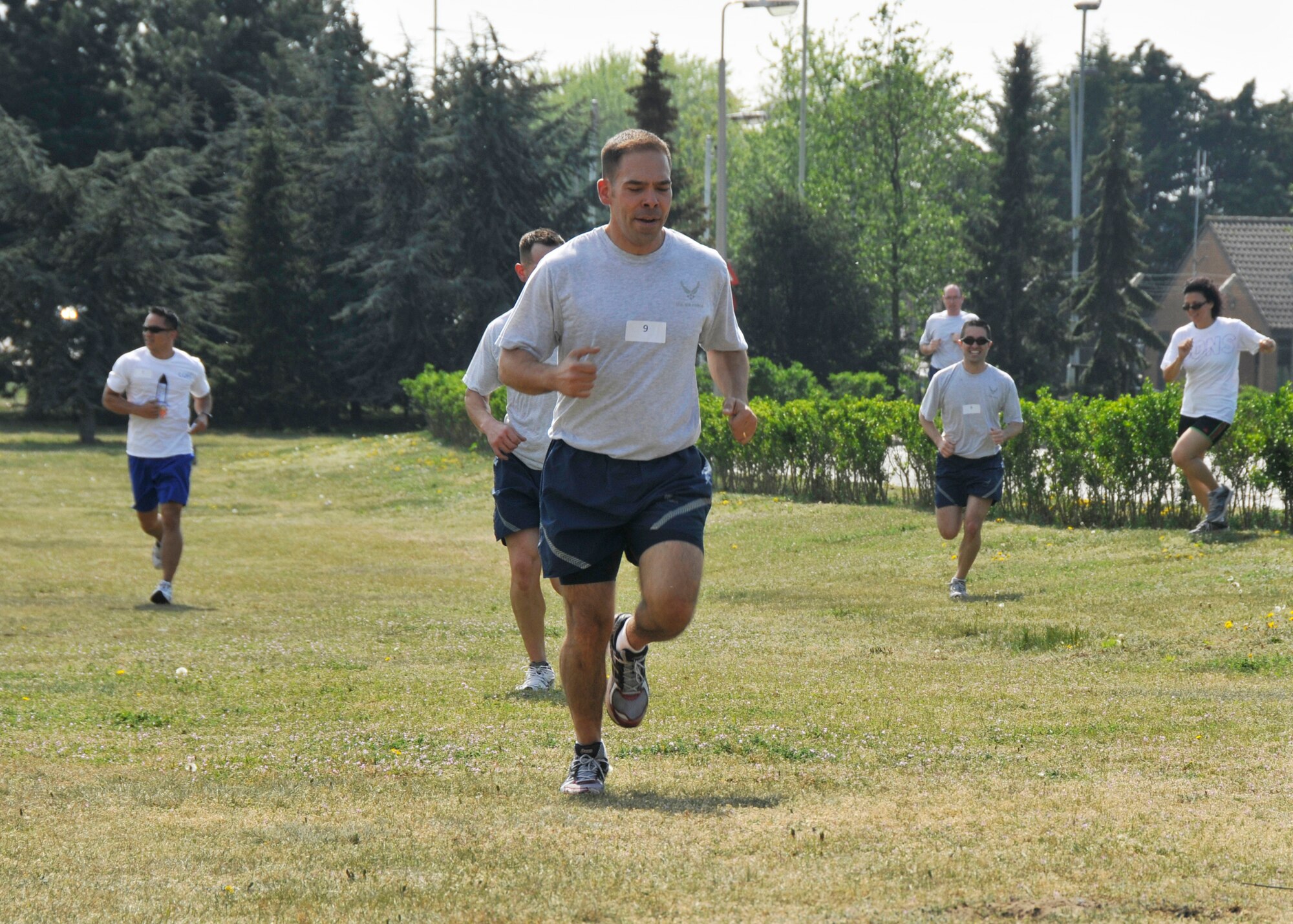ROYAL AIR FORCE LAKENHEATH, England - Airmen run to Defender Park during the Sexual Assault Awareness Month Amazing Race on April 22, 2011. Nine teams of four people were given clues to each new location they had to run to. At each location, they were given a SAAM associated question. If answered correctly, they were given their next clue. If answered incorrectly, they had to re-do the challenge for that area. Challenges included basketball free-throws, finding a book at the library, drinking eight cups of water per team, catching a water balloon, performing a touch-down dance and running laps around the track. (U.S. Air Force photo/Senior Airman Tiffany M. Deuel)