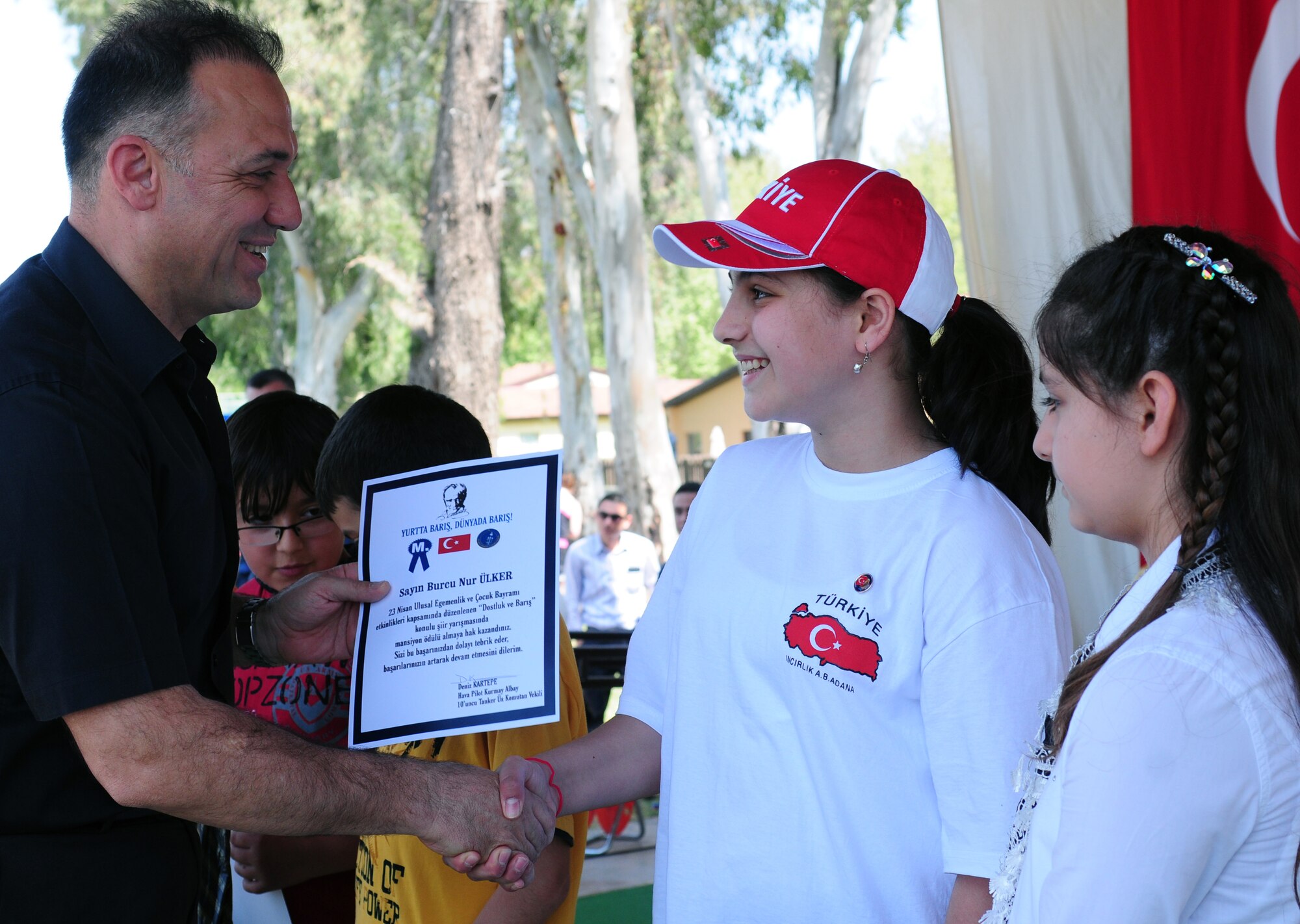 Col. Deniz Kartepe, the commander of the 10th Tanker Command, presents a certificate to Sayin Burcu Nur ?lker for her honorable mention in the National Sovereignty and Children?s Day Art and Poetry contest at a Children?s Day festival April 17, 2011, at Incirlik Air Base, Turkey. The event was hosted by the Turkish air force 10th Tanker Command and was open to all Incirlik personnel. The event offered an opportunity for camaraderie and partnership-building for all personnel here, and was a chance to celebrate both Turkish children on their national holiday and military children during the Month of the Military Child, officials said.  (U.S. Air Force photo by 1st Lt. Gina McKeen/Released)