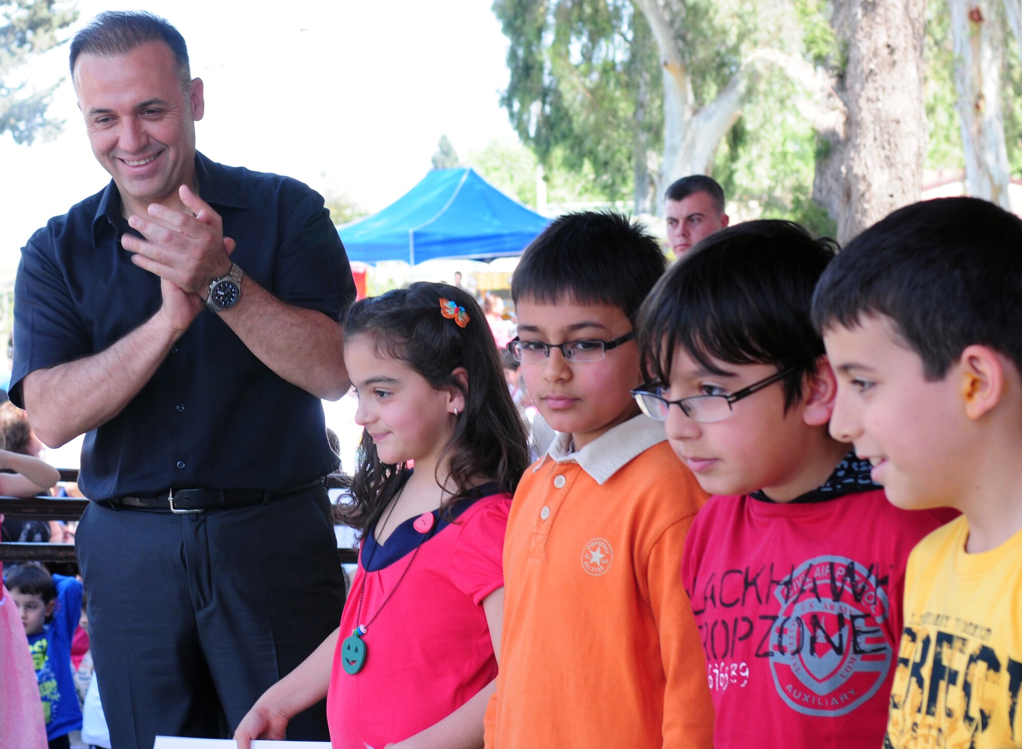 Col. Deniz Kartepe, the commander of the 10th Tanker Command, presents certificates to winners of the Art and Poetry contest at a Children?s Day festival April 17, 2011, at Incirlik Air Base, Turkey. The event was hosted by the Turkish air force 10th Tanker Command and was open to all Incirlik personnel. The event offered an opportunity for camaraderie and partnership-building for all personnel here, and was a chance to celebrate both Turkish children on their national holiday and military children during the Month of the Military Child, officials said.  (U.S. Air Force photo by 1st Lt. Gina McKeen/Released)